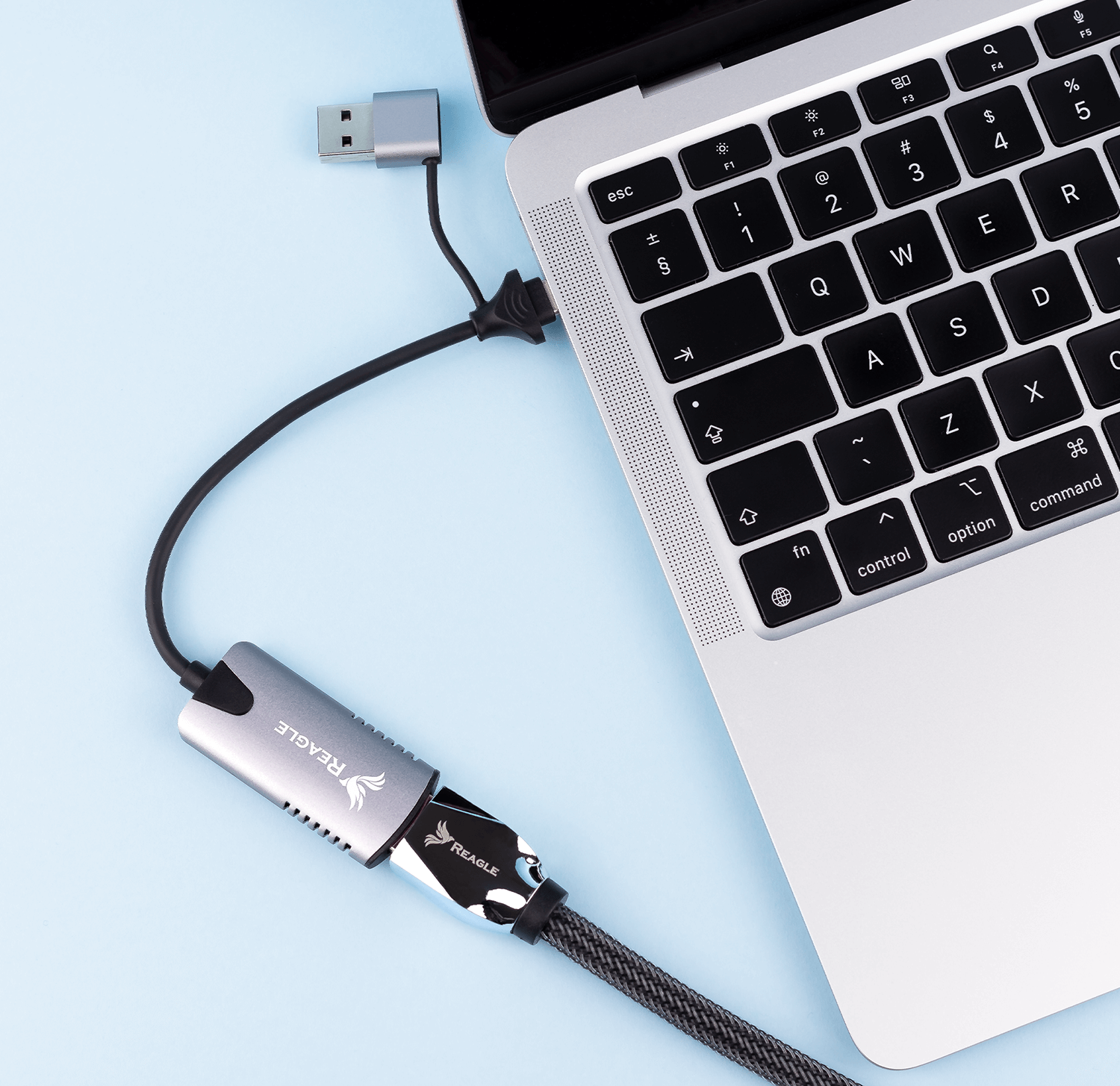 Laptop z podłączonym kablem i adapterem w kolorze srebrnym.