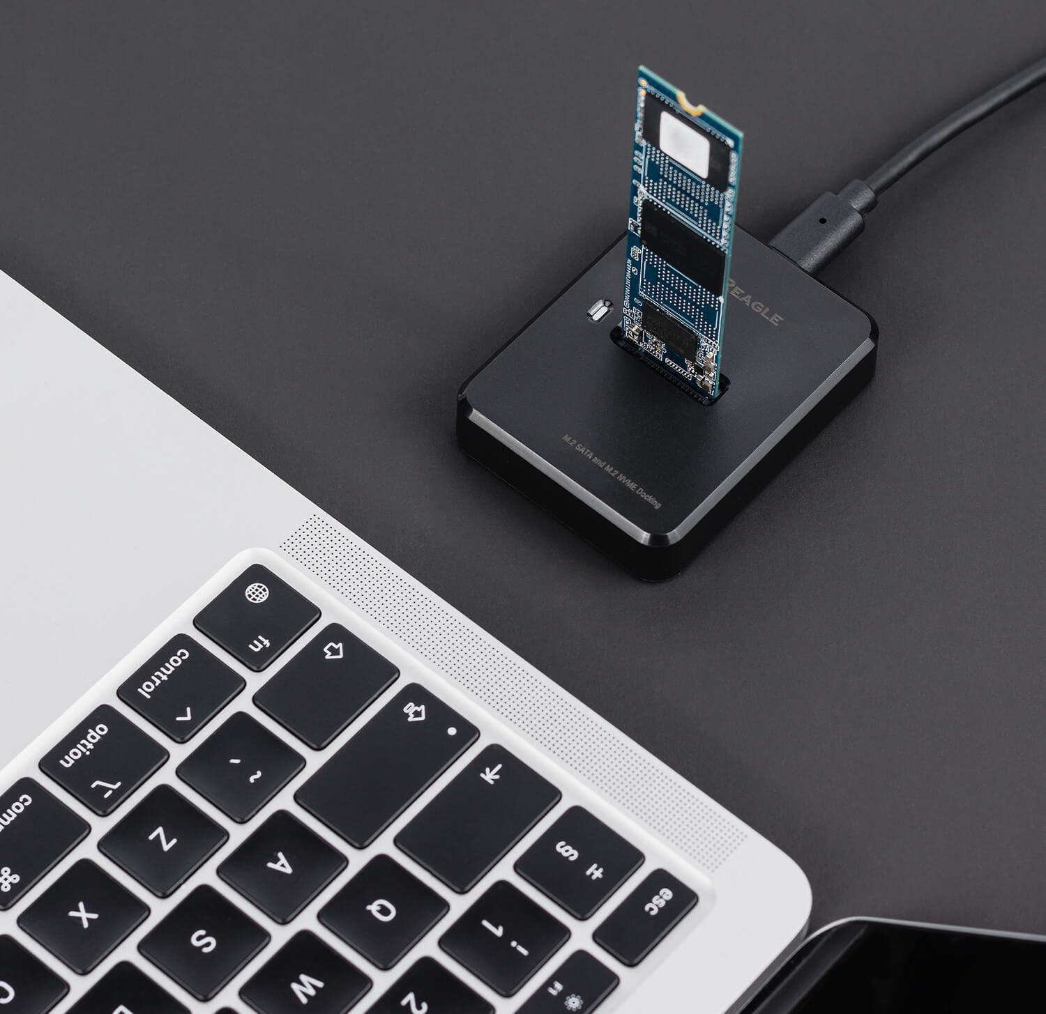 Externes Festplattengehäuse mit einer M.2 SSD, über USB-Kabel mit einem Laptop verbunden.