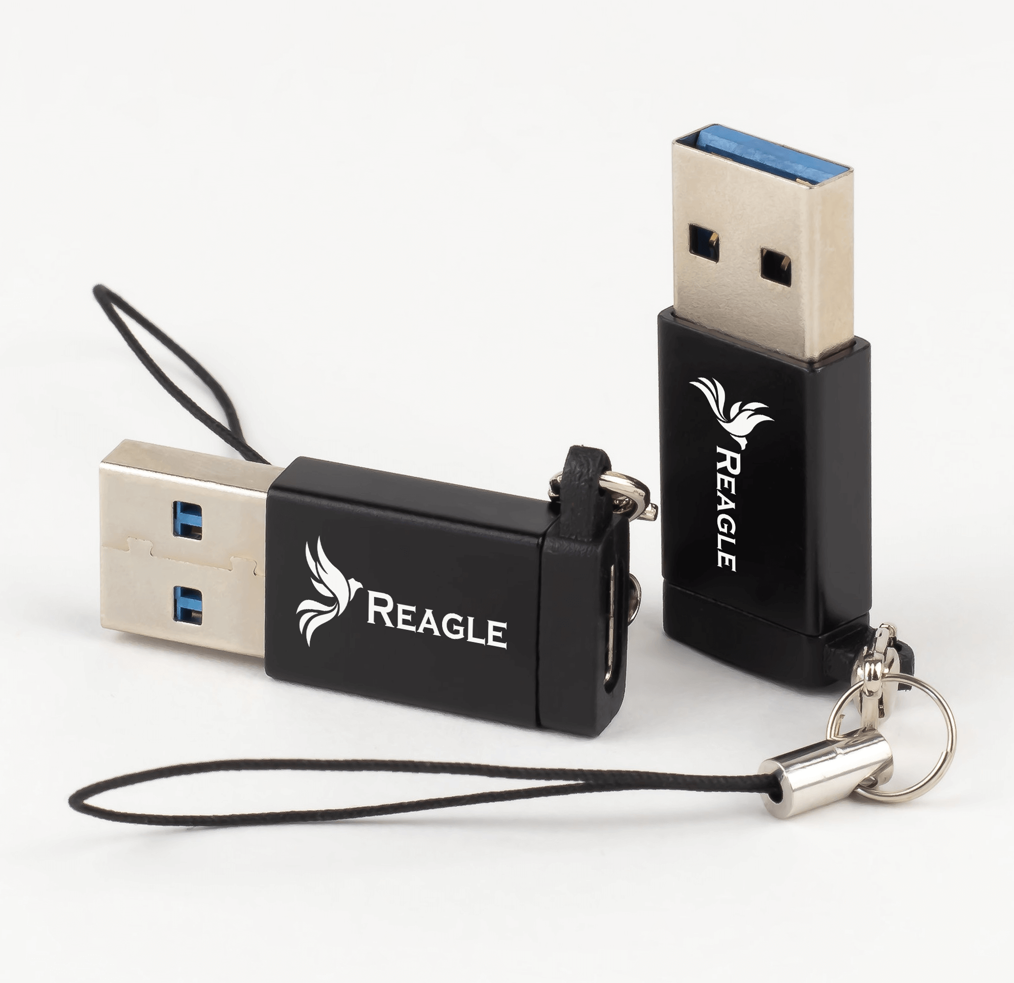 Dwa czarne pendrive'y USB. Oba mają białe logo. Jeden jest połączony z czarną smyczą.