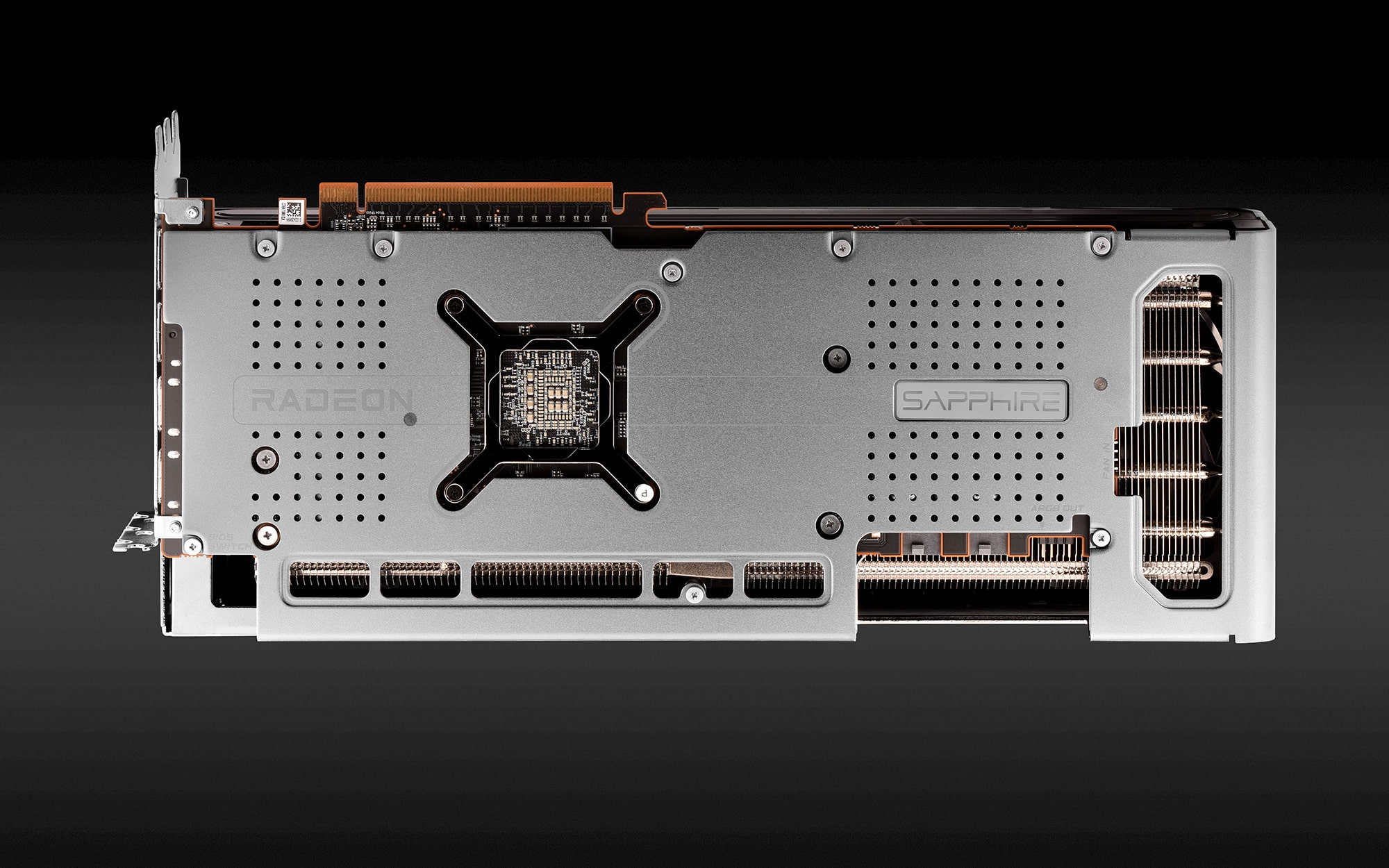 Parte trasera de una tarjeta gráfica plateada con las palabras 'Radeon' y 'Sapphire'.