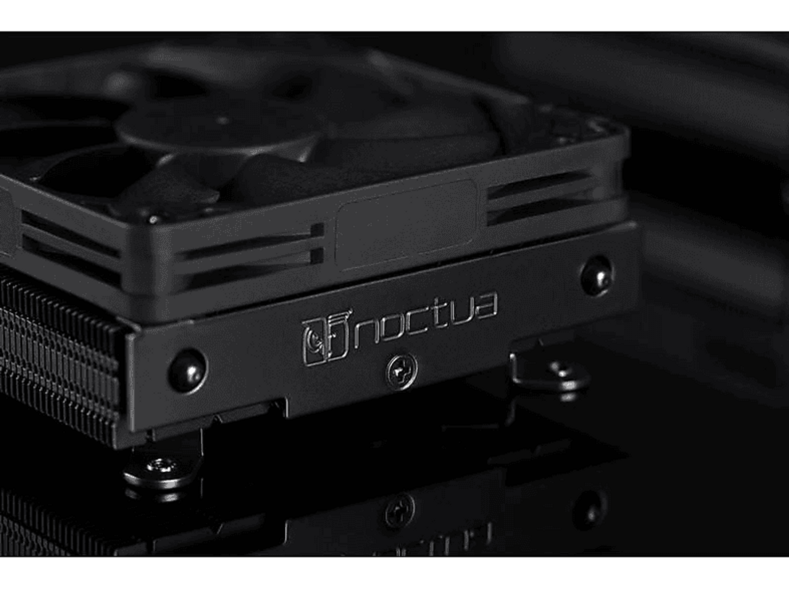 Czarny cooler CPU Noctua. Cooler jest kwadratowy, z wentylatorem i logo Noctua.