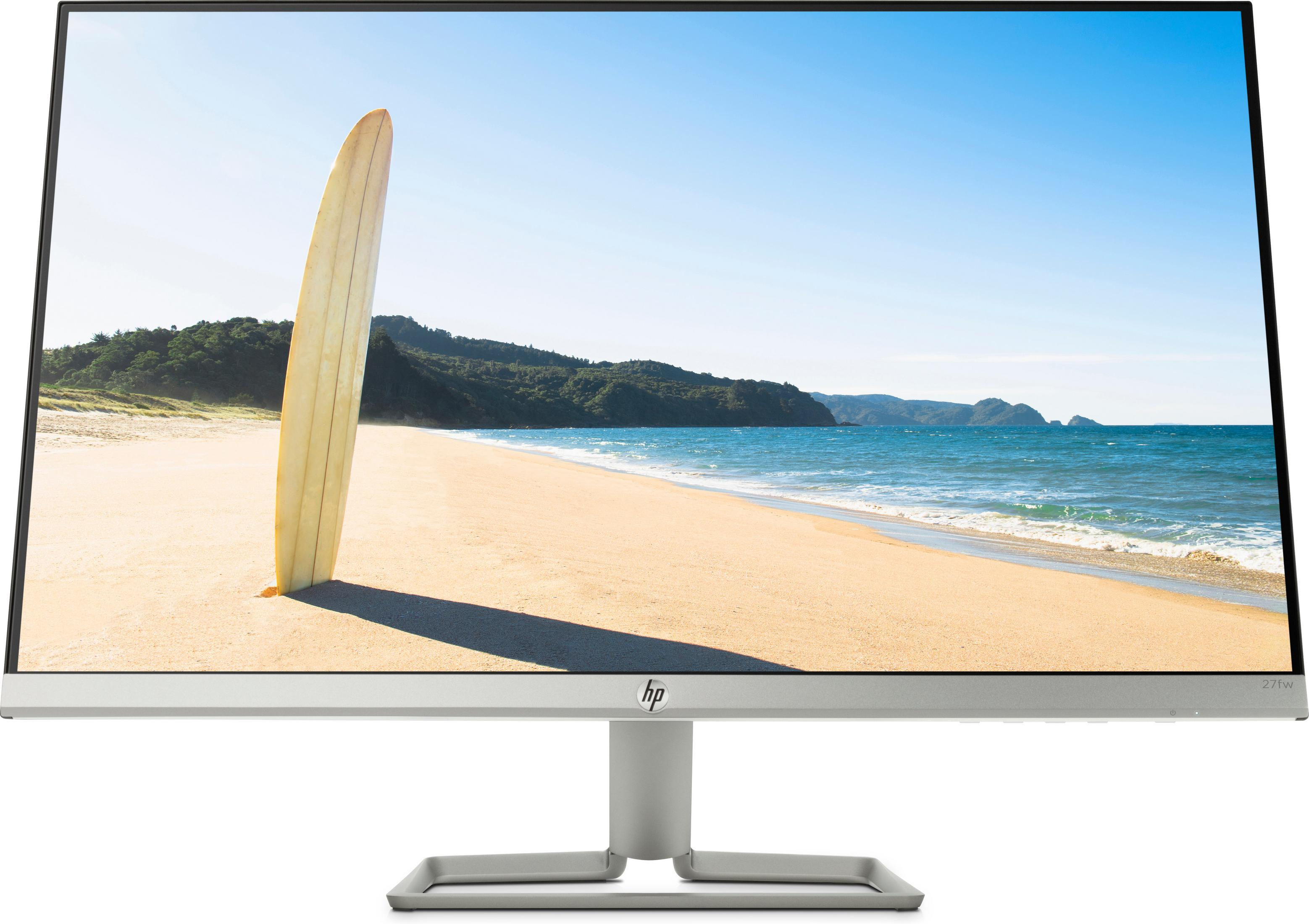 Il monitor mostra una scena di spiaggia con una tavola da surf. Cielo blu e oceano sullo sfondo.
