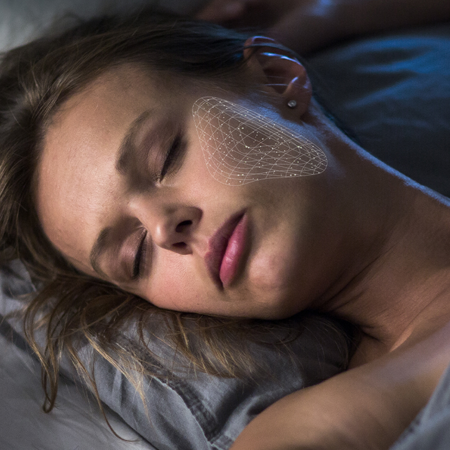 Mujer con ojos cerrados, rejilla blanca en mejilla, acostada en cama.
