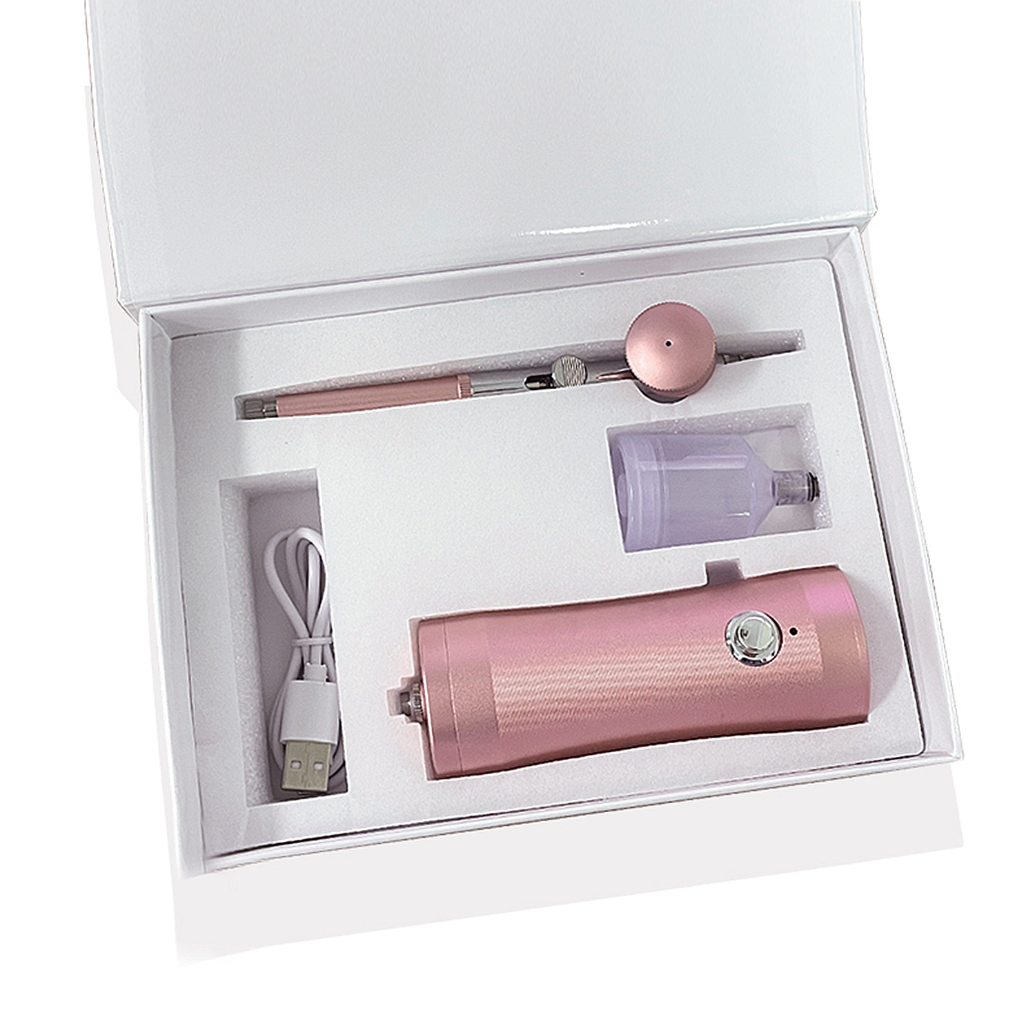 Un kit de aerógrafo rosa en una caja blanca. Incluye un bolígrafo, un motor y un recipiente.