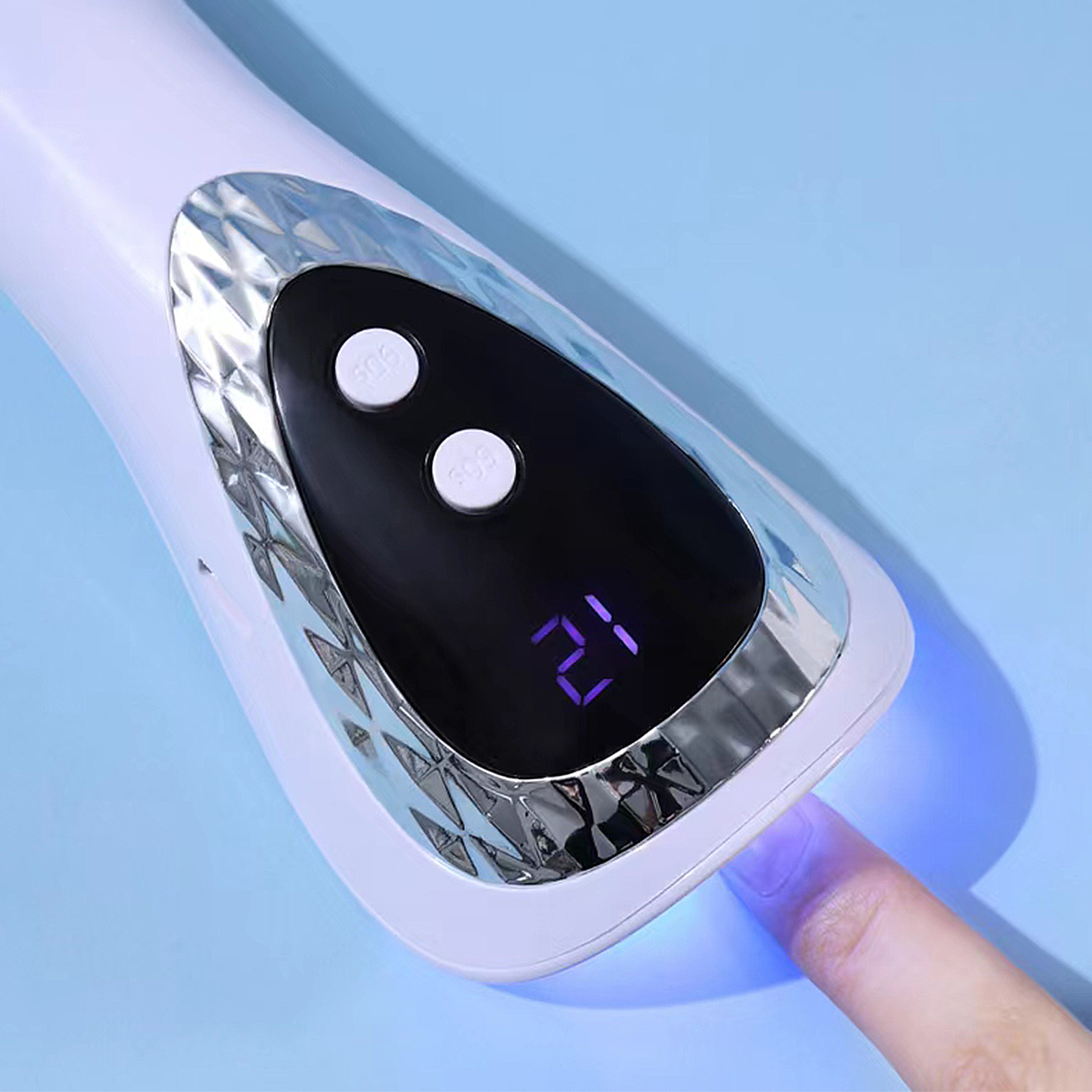 Asciuga unghie bianco con due pulsanti e display digitale che mostra '21'. Un dito sotto la luce.