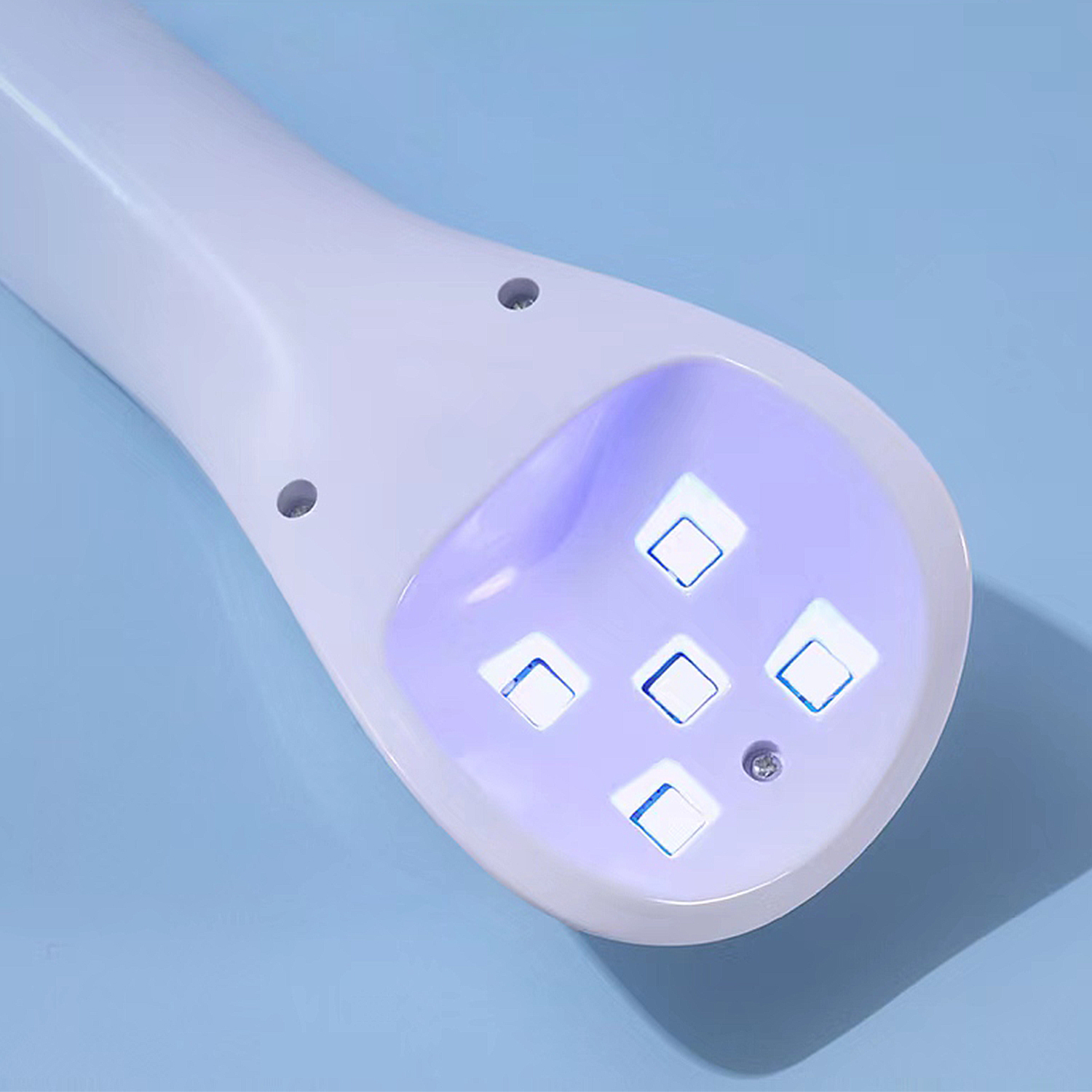 Una lampada per unghie UV bianca con luci blu su sfondo blu.