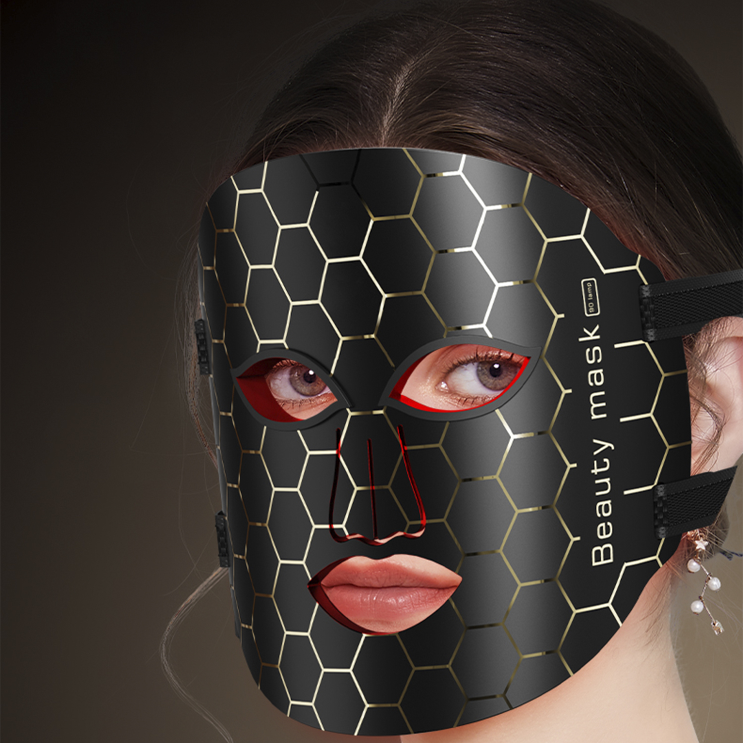 Una mujer lleva una mascarilla facial negra hexagonal. Sus ojos y labios son visibles.