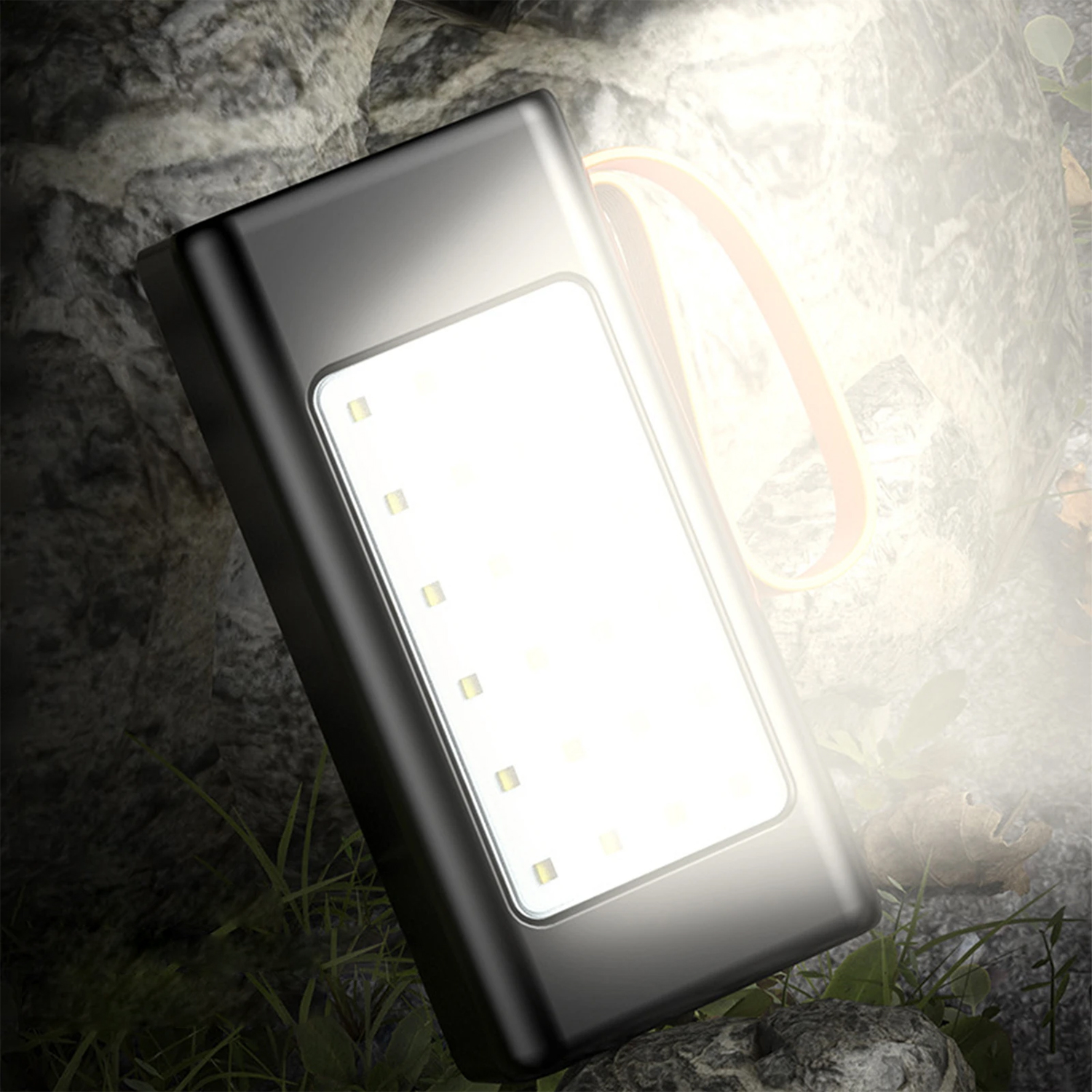 Una linterna negra con luz brillante sobre un fondo oscuro. La luz brilla intensamente.