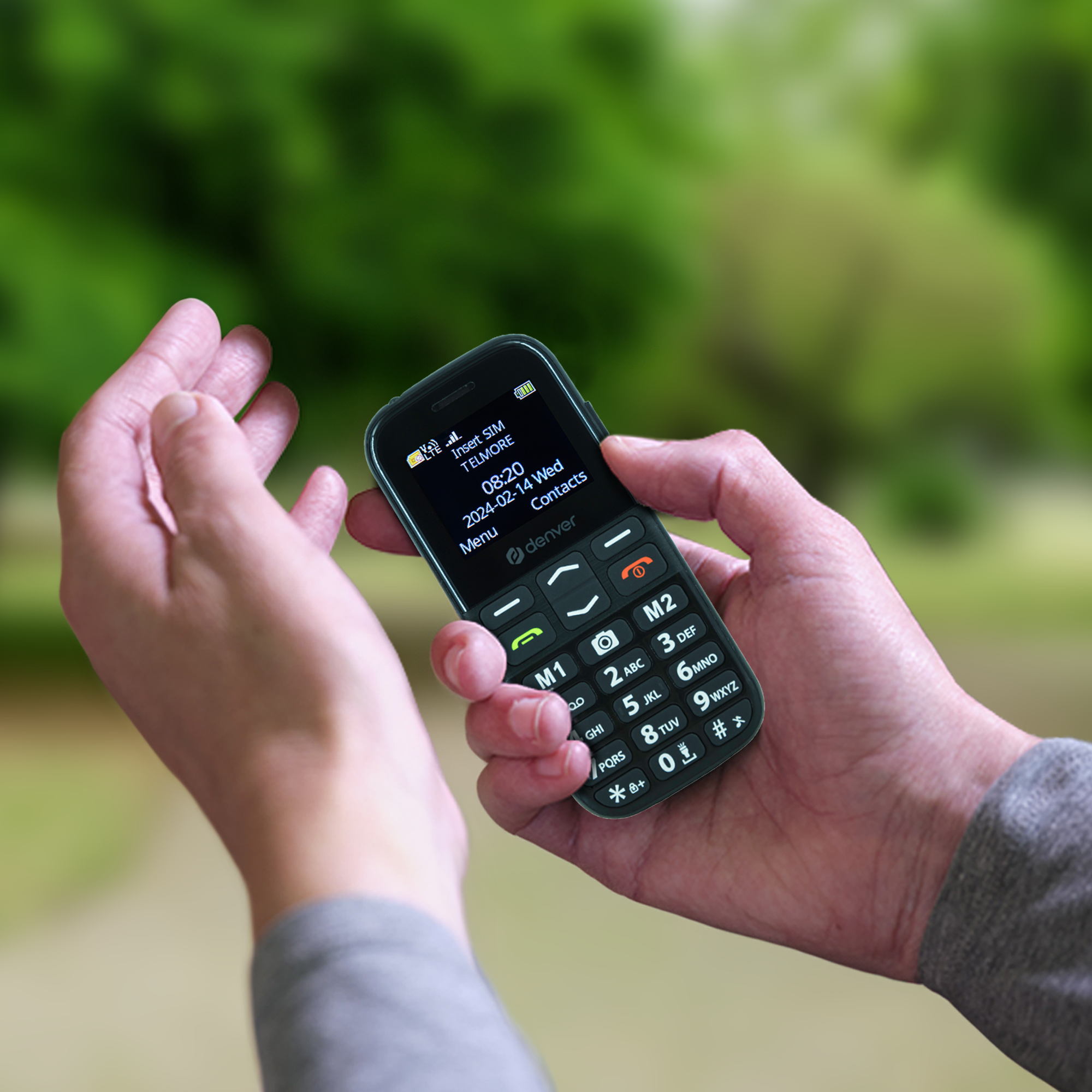 Una persona sosteniendo un teléfono celular negro.