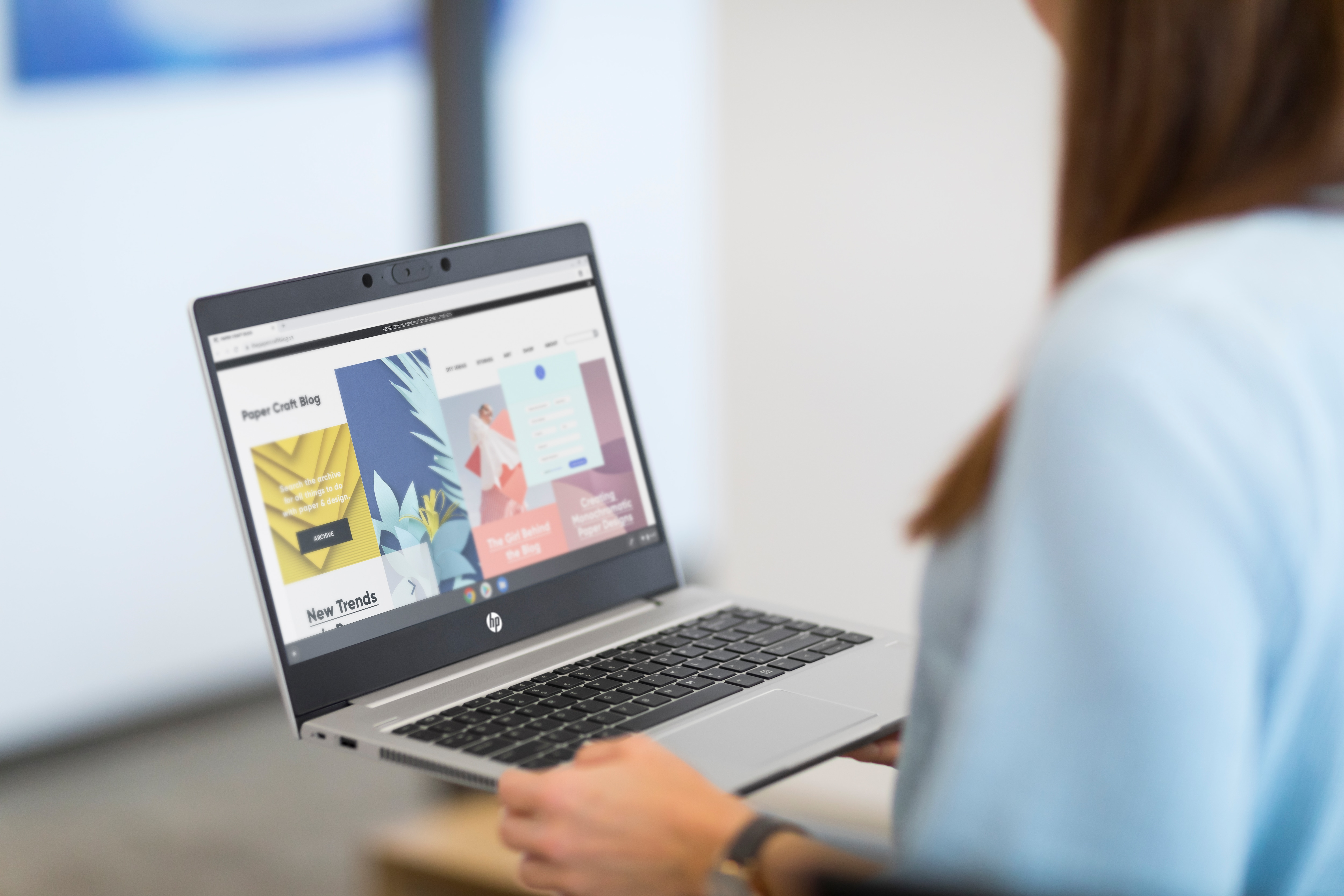 Una persona che tiene un laptop argentato che mostra un sito web.
