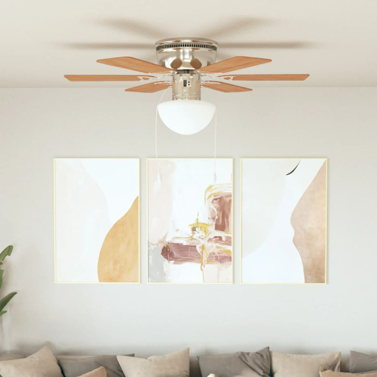 Ventilatore a soffitto con pale in legno e tre dipinti astratti incorniciati.
