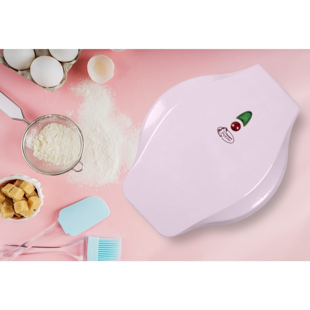 Scena di cucina con ingredienti per la cottura e un elettrodomestico bianco, con sfondo rosa.