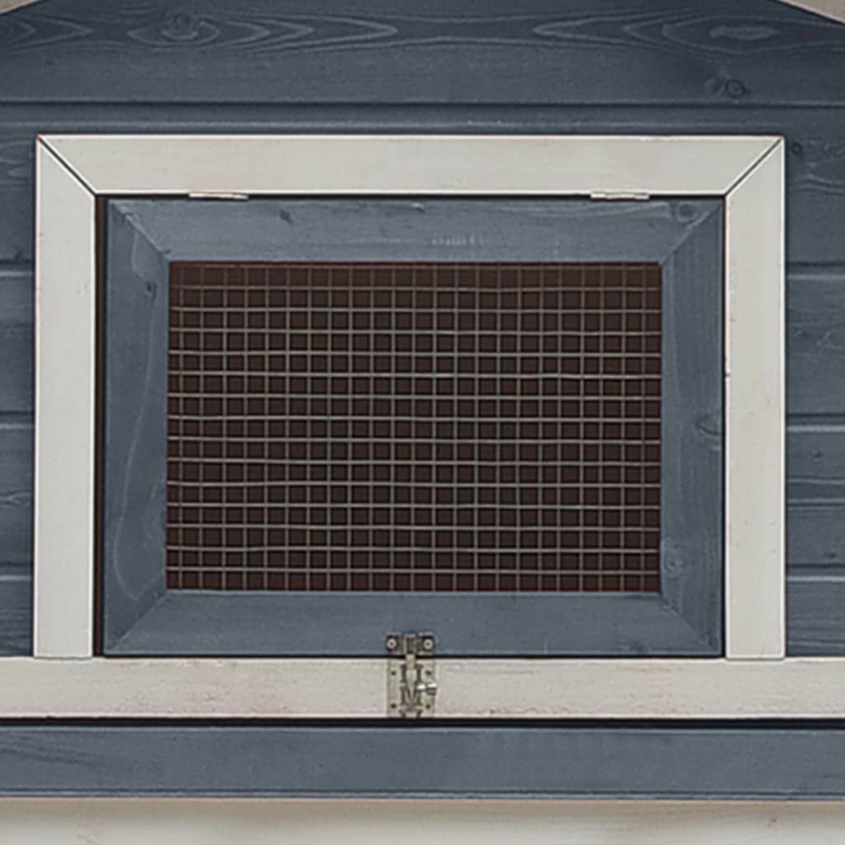 Nahaufnahme eines Fensters mit Drahtgeflecht. Es ist ein dunkles Rechteck mit weißem Rahmen.