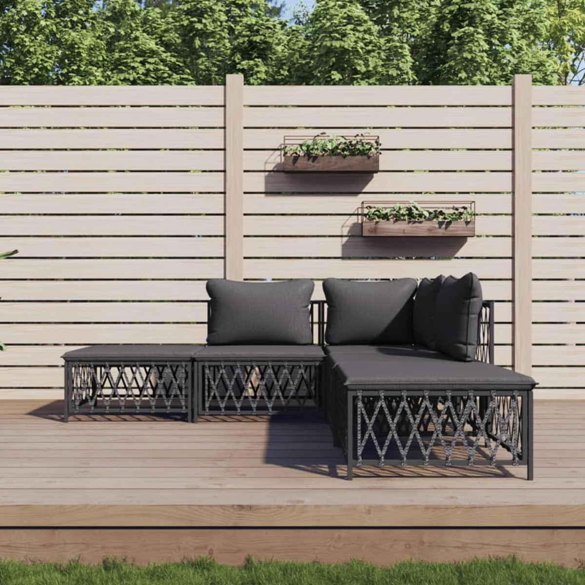 Schwarzes Gartenmöbel-Set auf einem Holzdeck. Pflanzen in Wandkästen, Holzzaun im Hintergrund.
