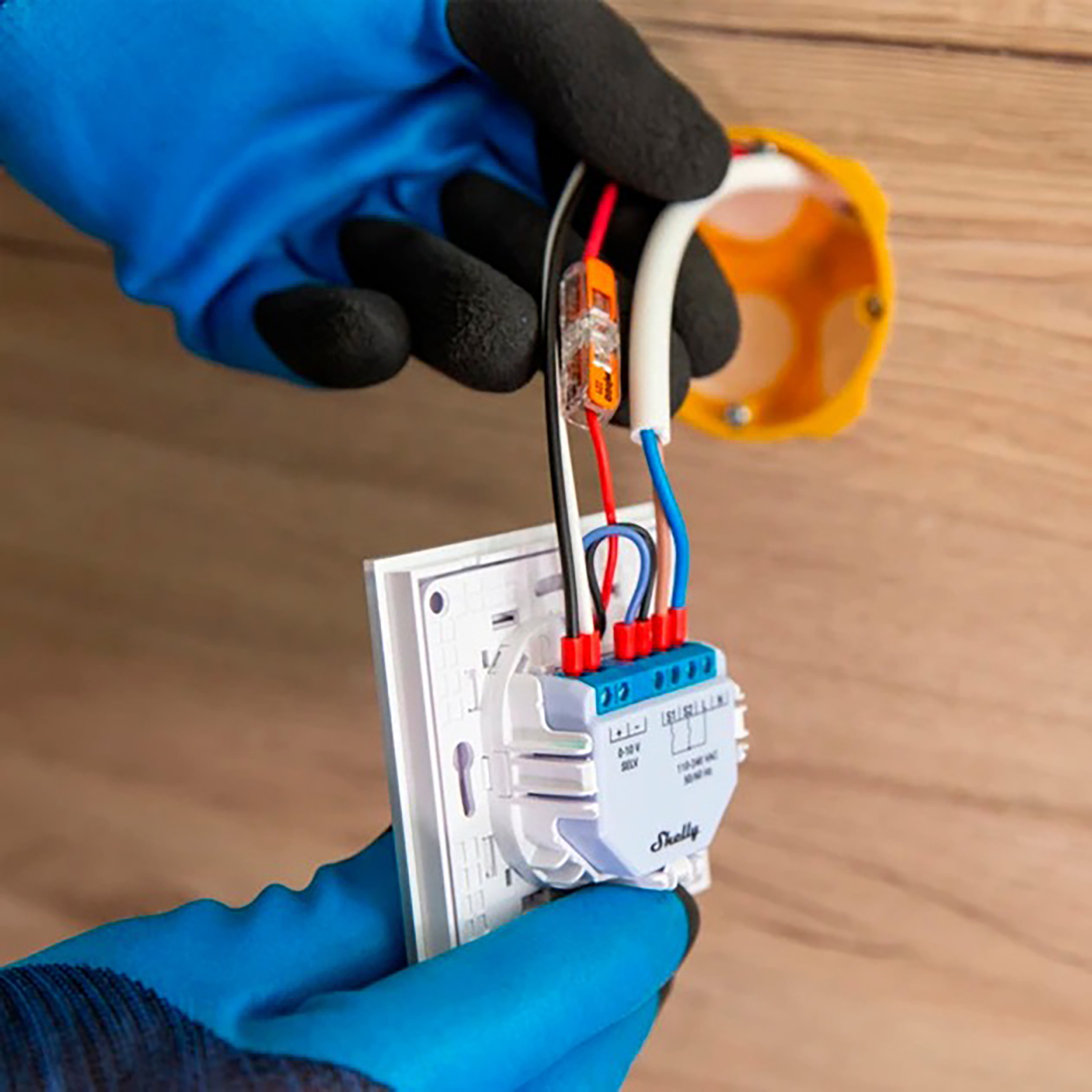 Manos instalando un interruptor inteligente con cables.