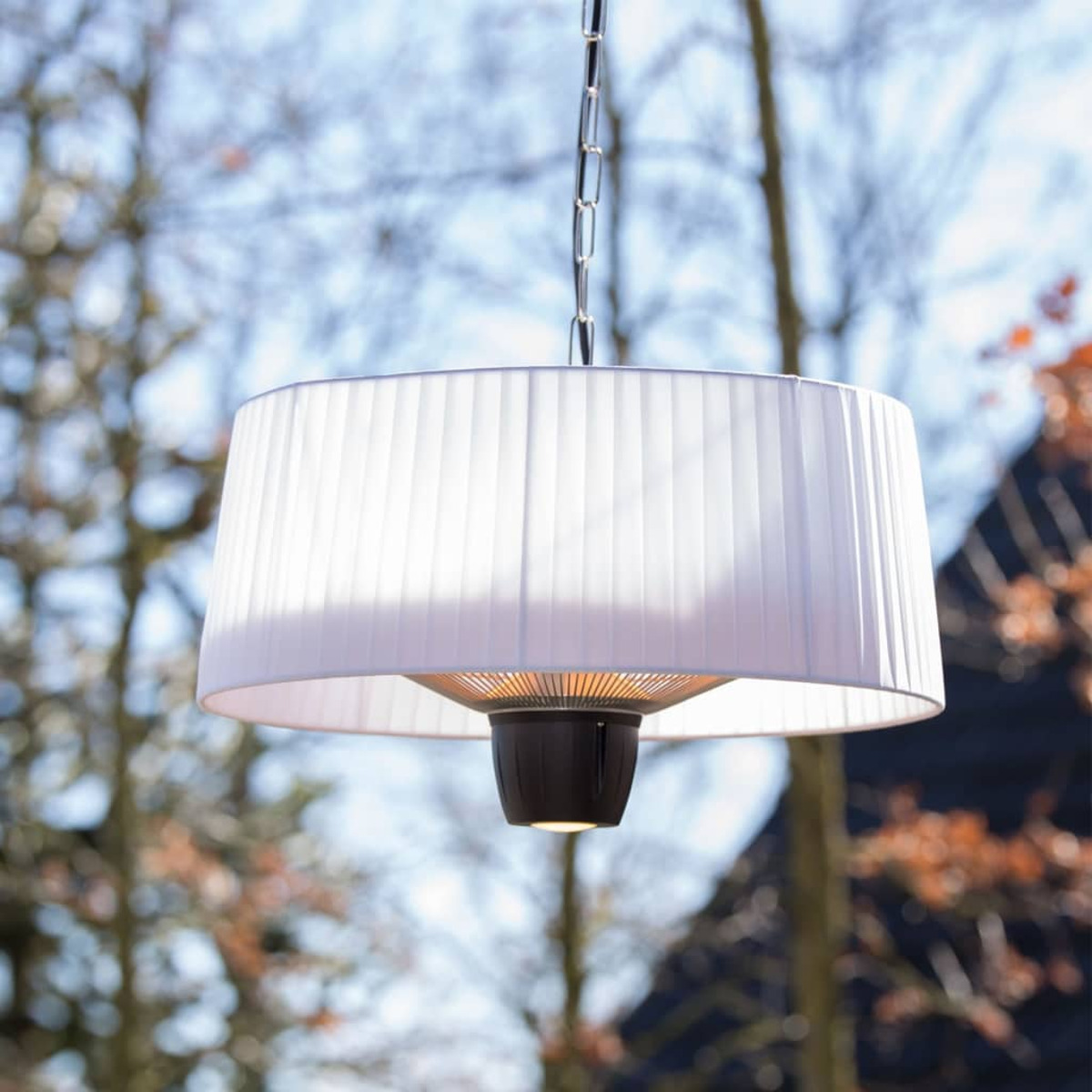 Hangende buitenkachel met een witte lampenkap en donkere basis, met bomen op de achtergrond.