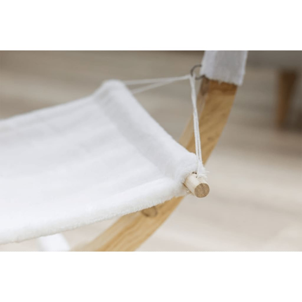 Hamaca para gatos de madera y tela blanca y esponjosa. Suspendida por cuerdas.