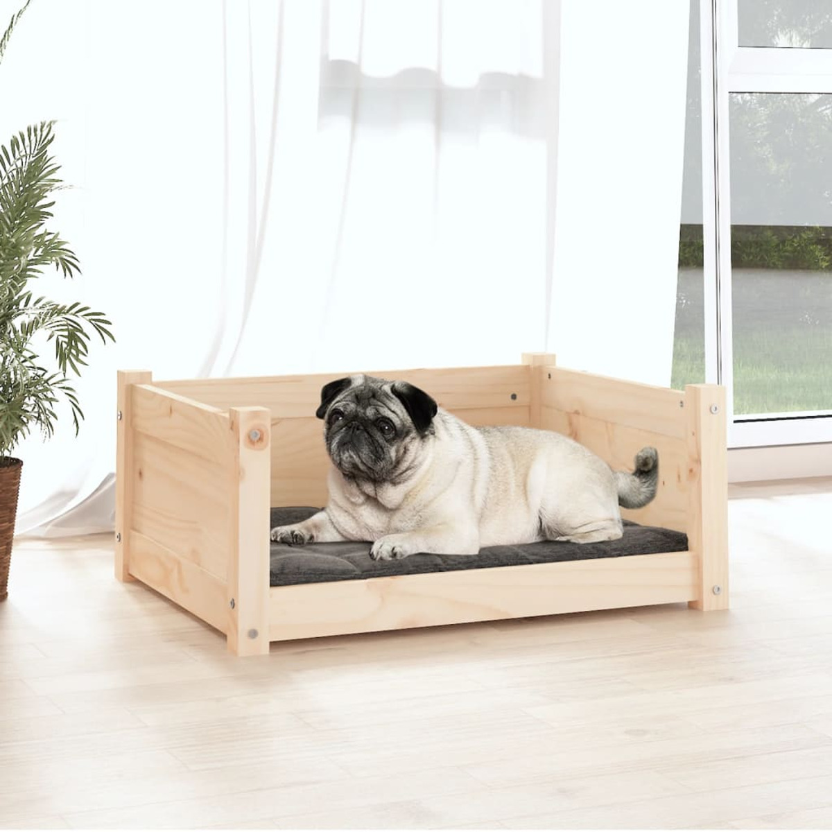 Ein helles Hundebett aus Holz mit einem Mops auf einem grauen Kissen. Im Hintergrund ein Fenster.