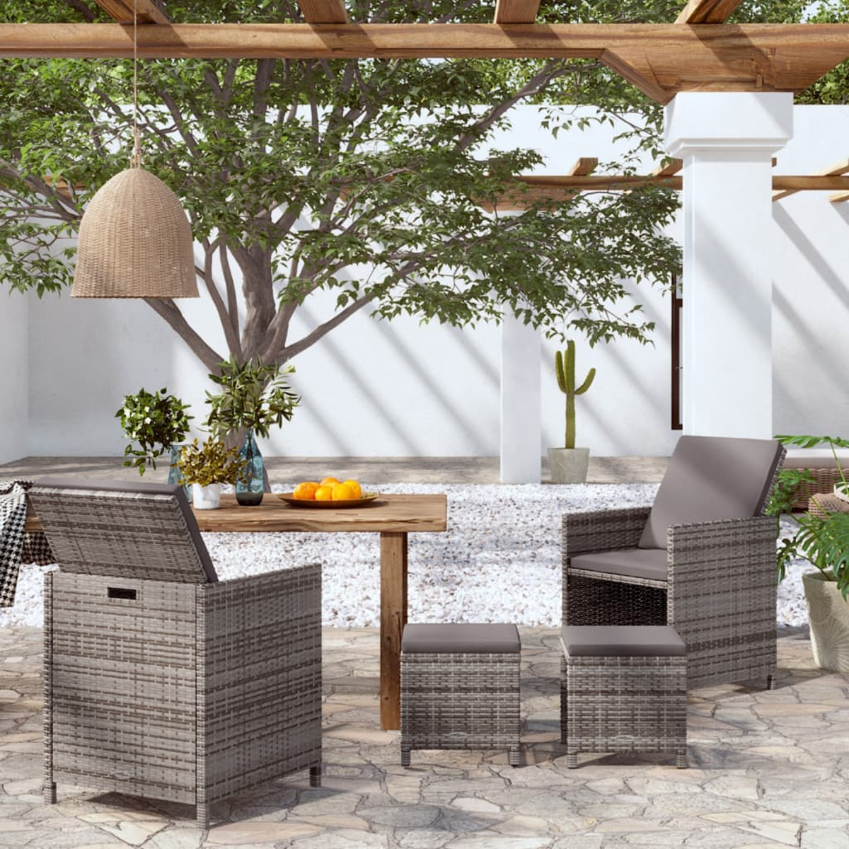 Geflochtenes Outdoor-Möbelset mit grauen Kissen und einem Holztisch. Outdoor-Setting.