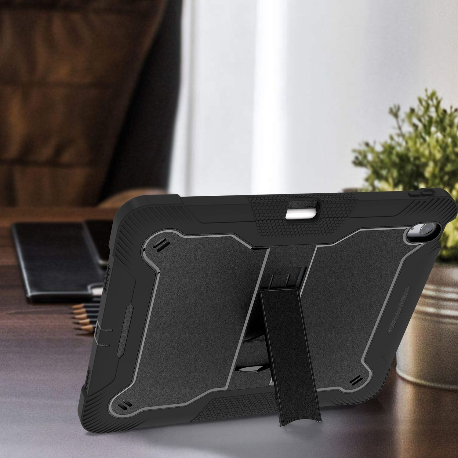 Schwarze Tablet-Hülle mit Ständer auf Holzschreibtisch, innen.