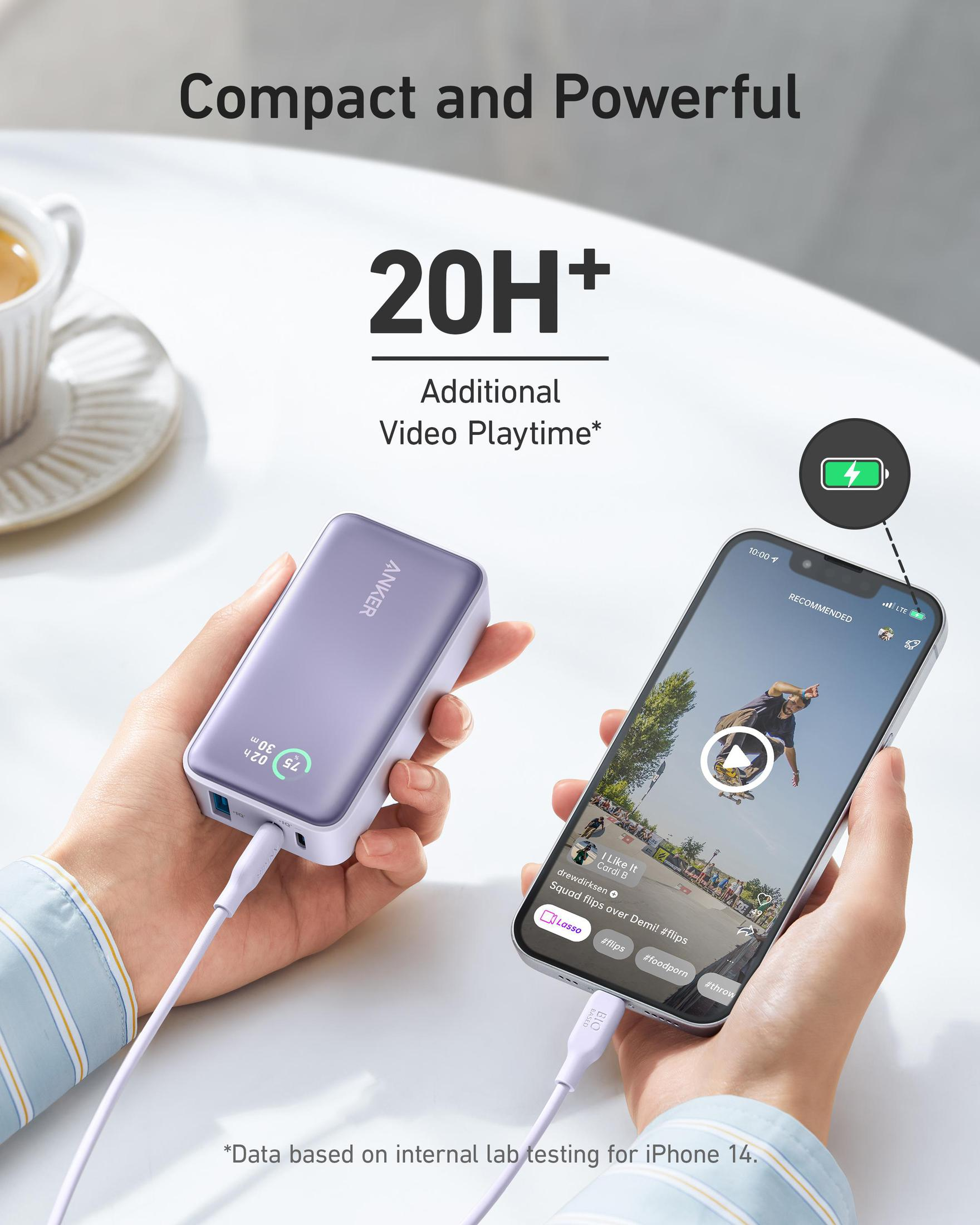 Power bank Anker viola tenuto da una persona con un telefono che mostra un video. Sfondo bianco.