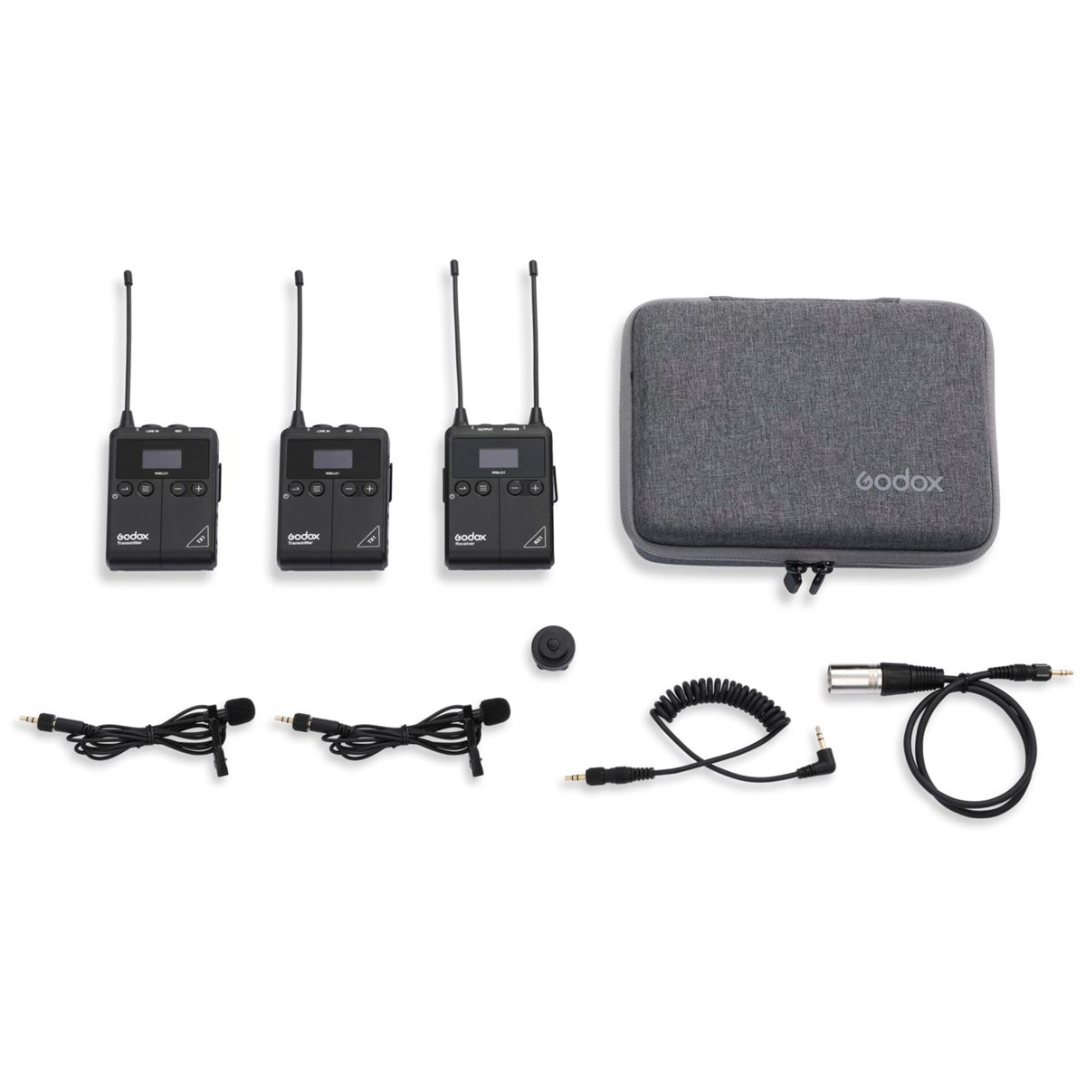 Set di microfoni wireless, trasmettitori e custodia, disposti ordinatamente su una superficie bianca.