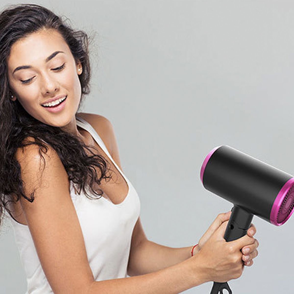 Frau hält einen schwarz-rosa Haartrockner.