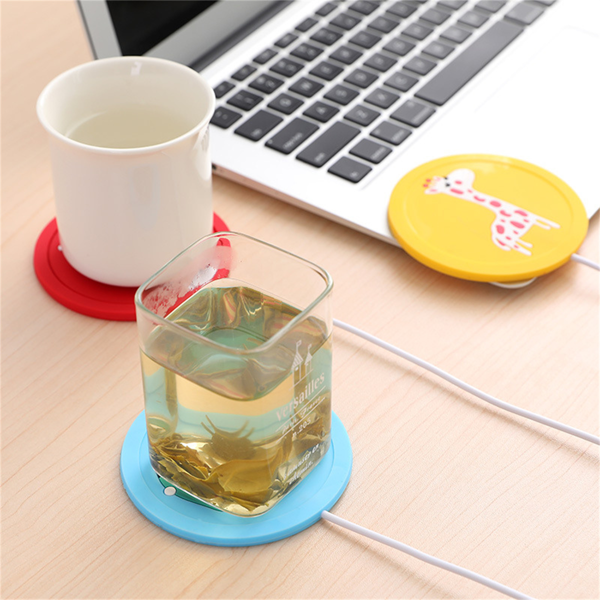 Tasse und Glas auf einem Tisch mit Laptop-Tastatur. Untersetzer vorhanden.