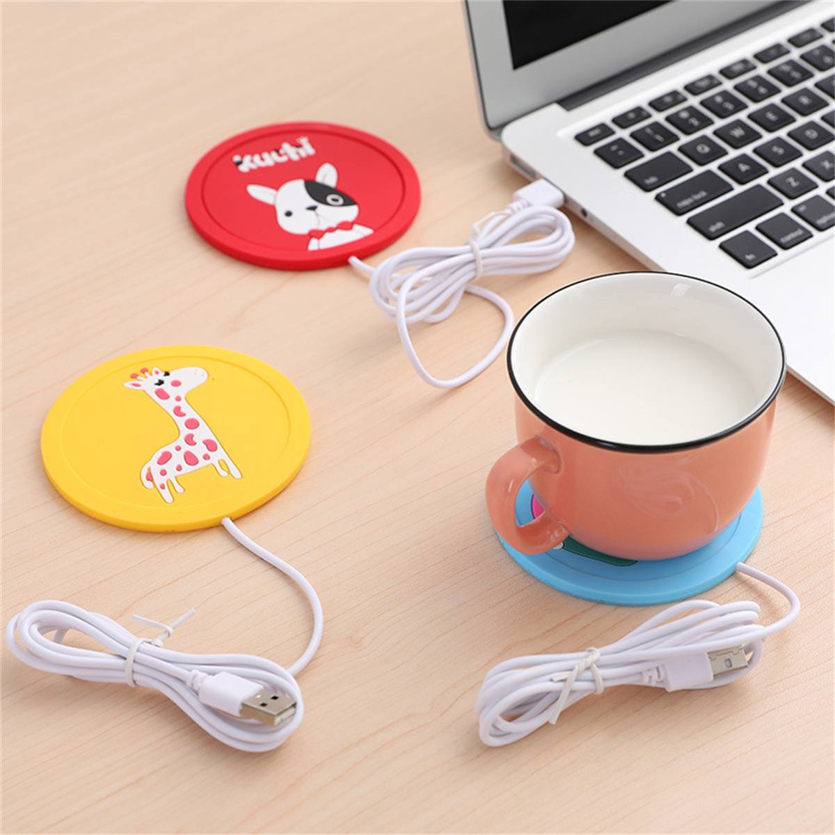 Ein Laptop, eine Tasse und drei bunte Untersetzer, zwei mit Tierbildern.
