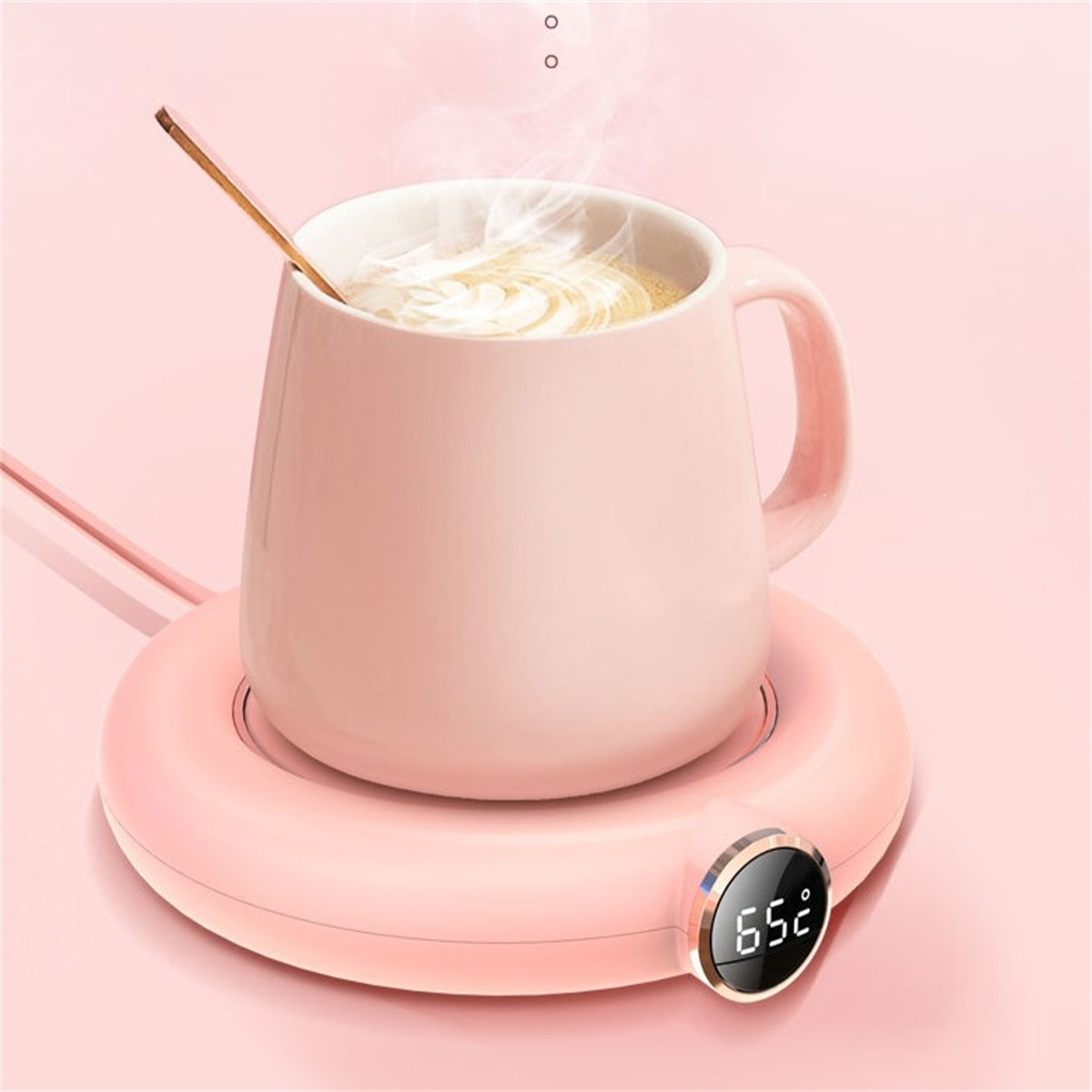 Ein rosa Becher auf einem rosa Wärmer mit einem Löffel.