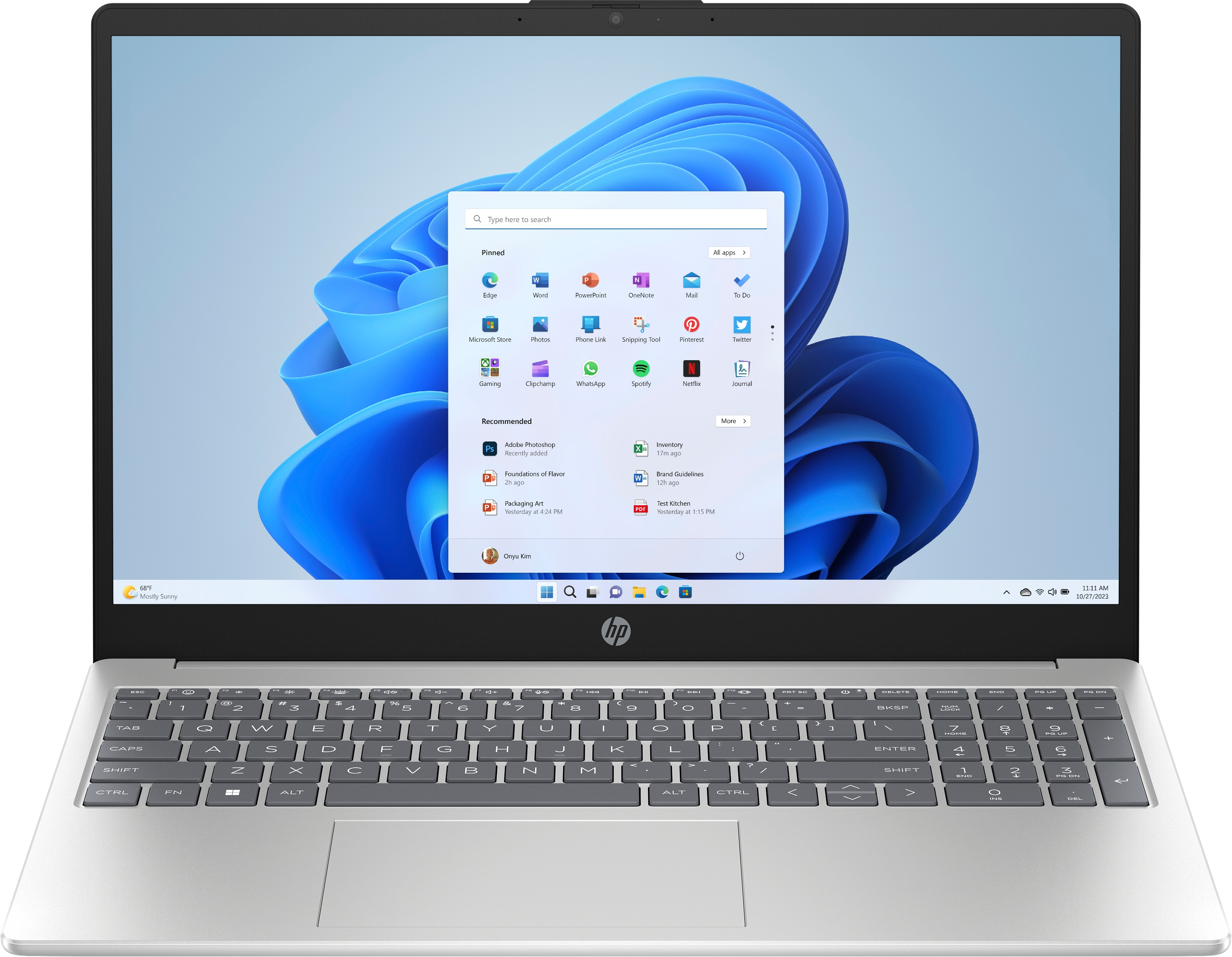 Zilveren laptop open, met Windows 11-interface met apps. Scherm is licht, achtergrond is wit.