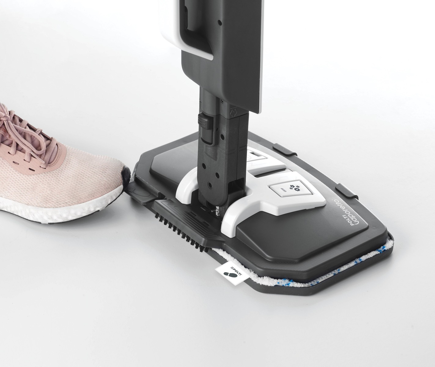 Stopa obok czarnej i białej mopy parowej. Białe tło.