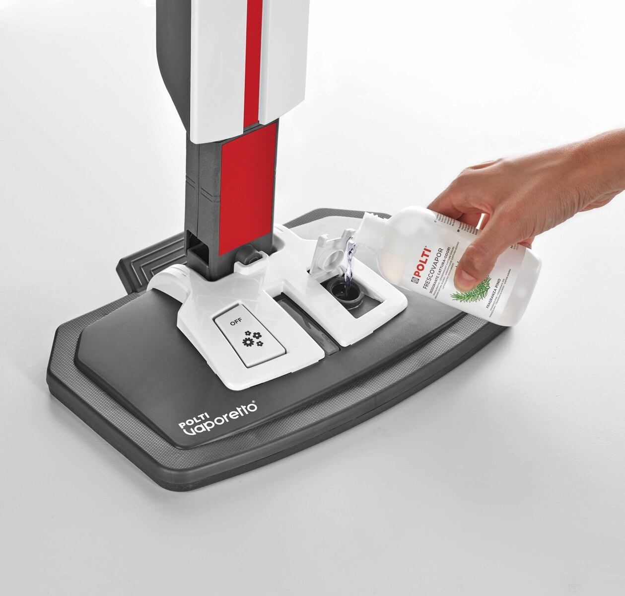 Osoba wlewa płyn z butelki do białej myjki parowej. Myjka jest na szarej podkładce.