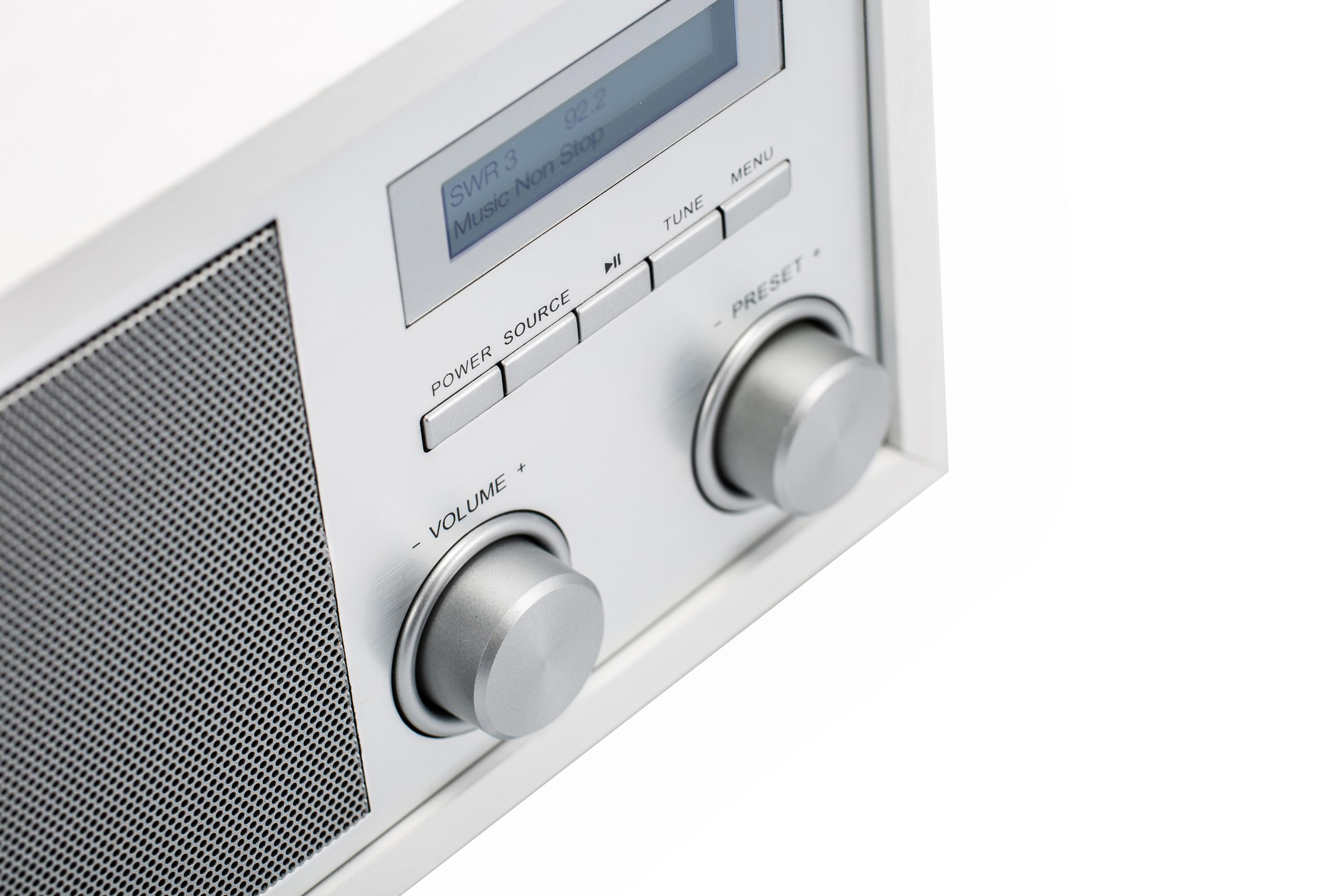 Nahaufnahme eines silbernen Radios mit Knöpfen und einem Bildschirm mit 'SWA 3 Music Non Stop', auf Weiß.