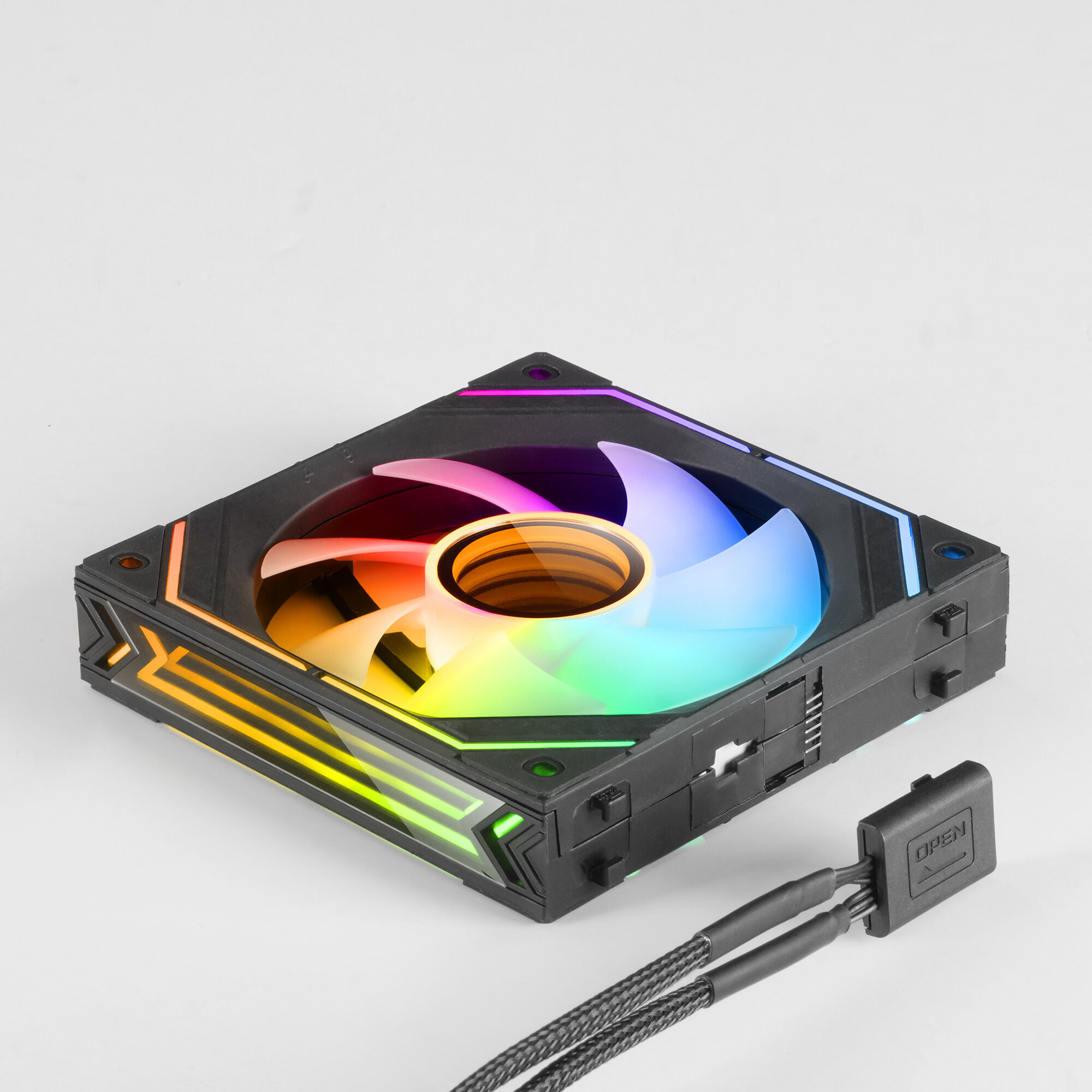 Una ventola per computer con luci colorate. È nera e ha un cavo collegato. Sfondo bianco.