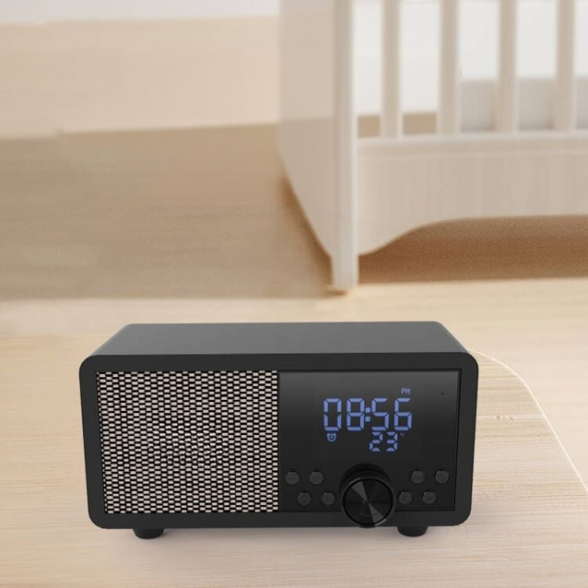 Schwarzes Digital-Radiowecker mit Zeitanzeige, Lautsprecher und Knöpfen auf Tisch.