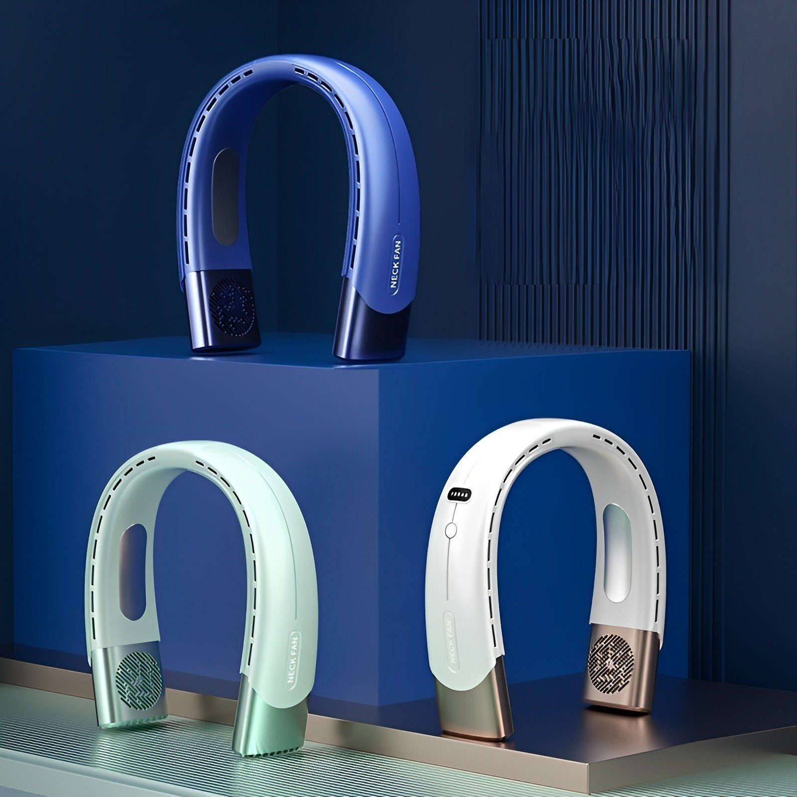Drei Nackenventilatoren in verschiedenen Farben: blau, weiß und weiß-gold, alle auf einer blauen Oberfläche.