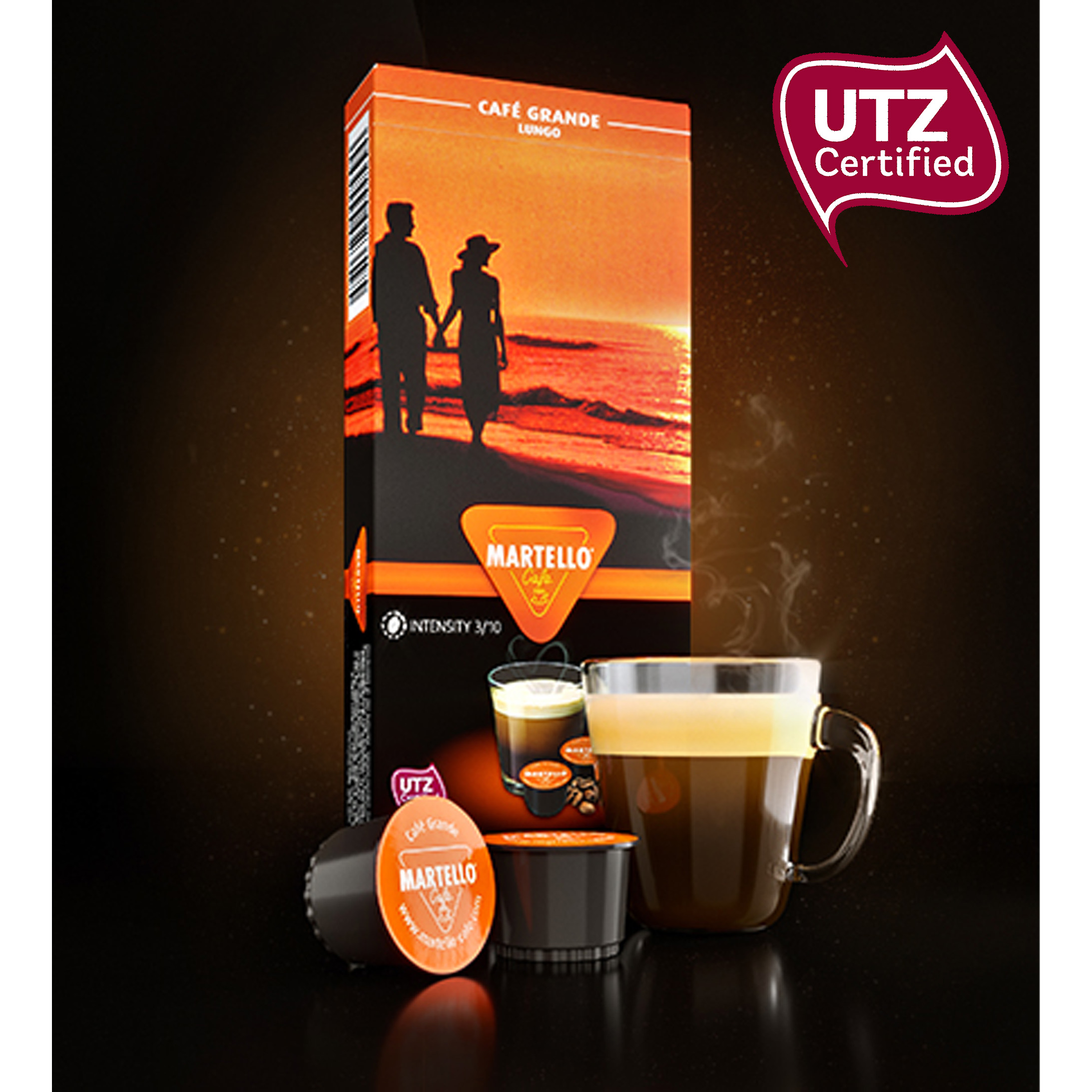 Capsule di caffè, una tazza di caffè e una scatola con un'immagine di una coppia al tramonto. Sfondo scuro.