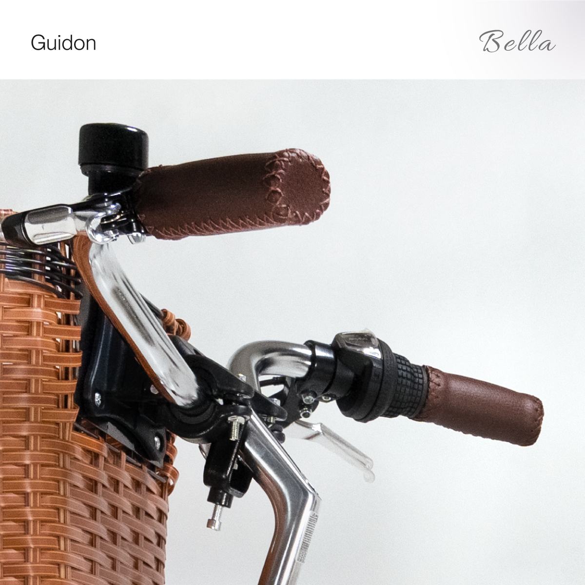 Nahaufnahme des Fahrradlenkers mit braunem Weidenkorb und braunen Ledergriffen.