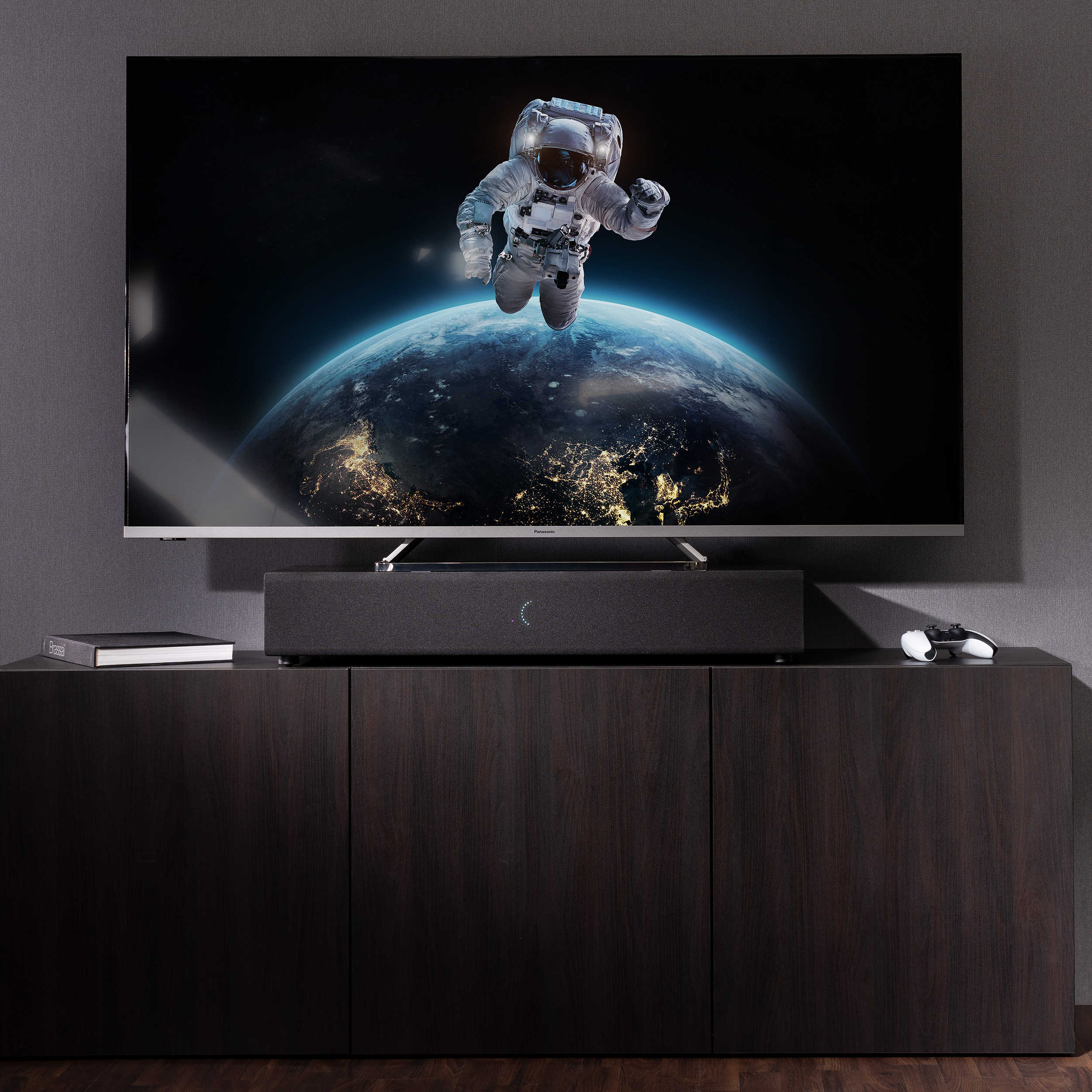 Astronaut im Weltraum auf TV. Soundbar und Schrank darunter.