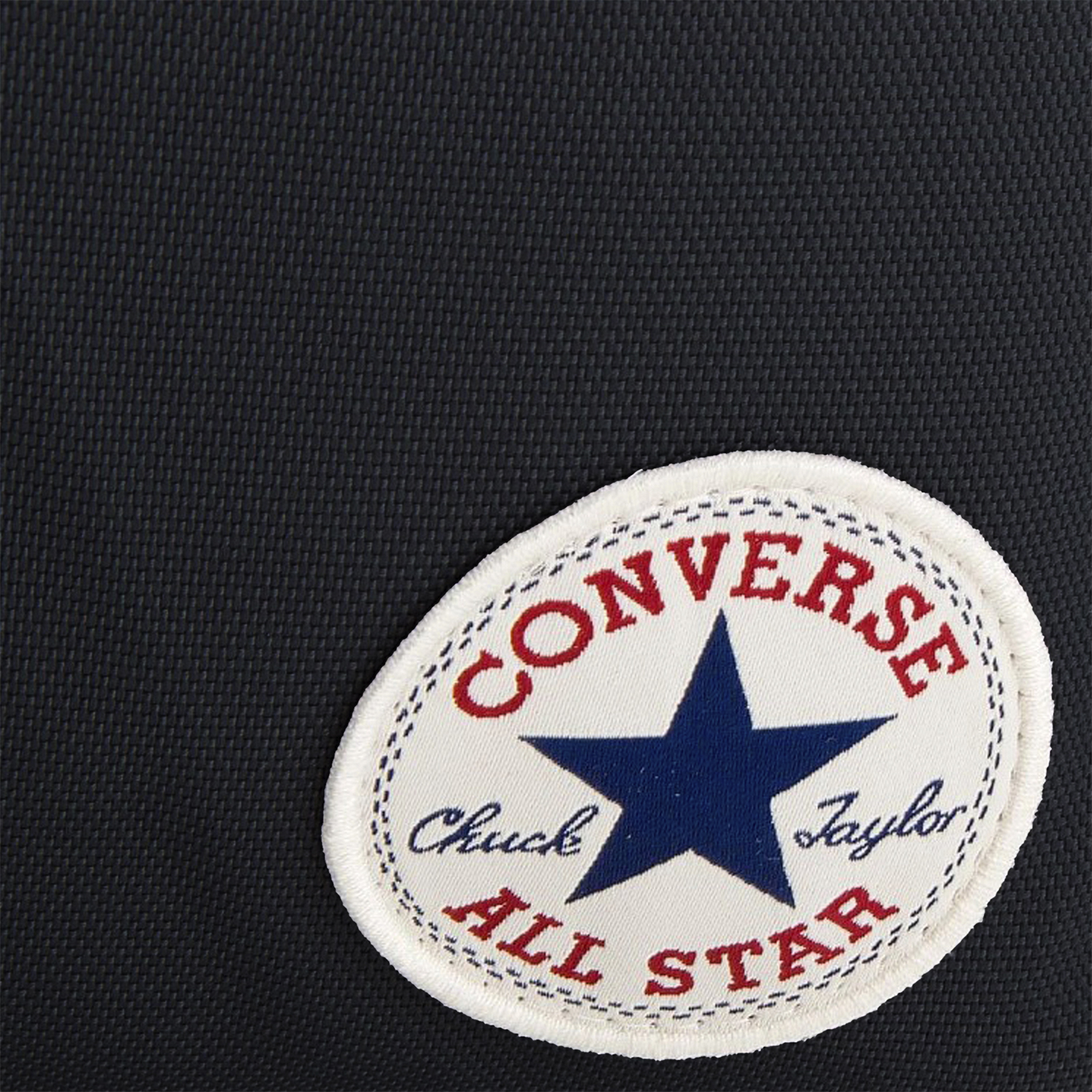 Primer plano de tela negra mostrando el parche del logo Converse All Star.