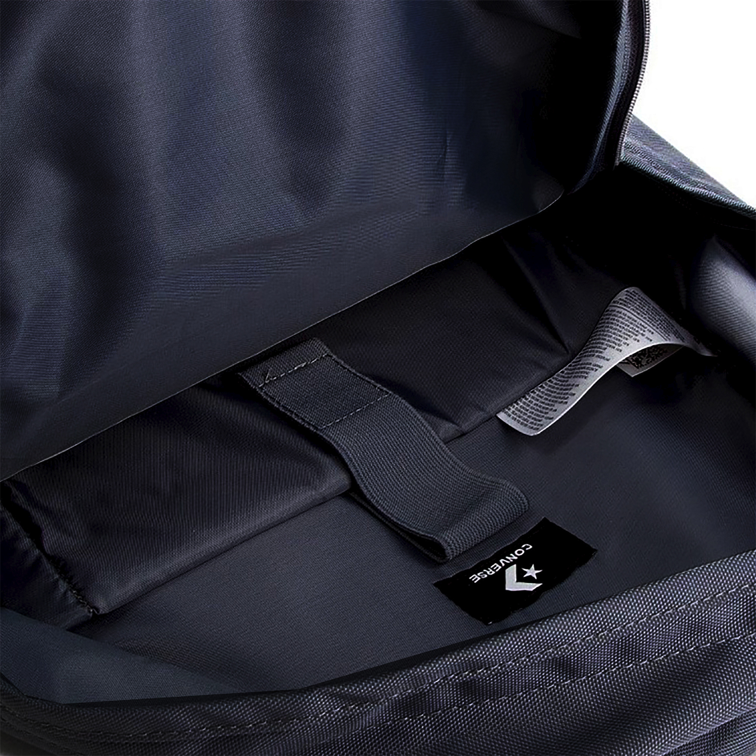 Mochila azul marino con interior que muestra etiqueta y bolsillos. La bolsa está abierta.