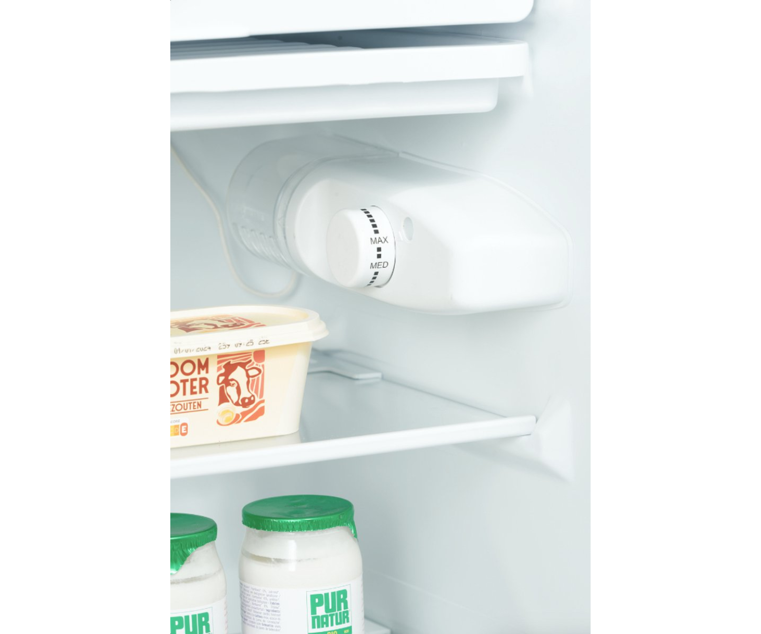 À l'intérieur d'un réfrigérateur. Un cadran est visible, ainsi que des aliments dans des contenants.