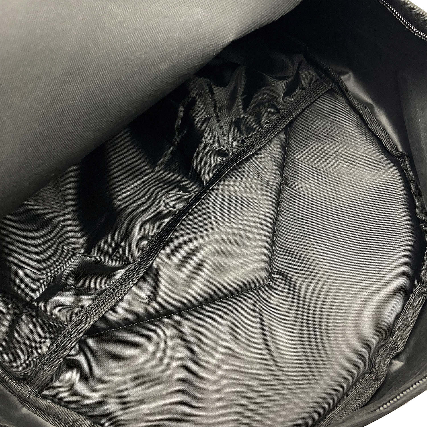 Interior de mochila negra abierta, mostrando el forro interior.