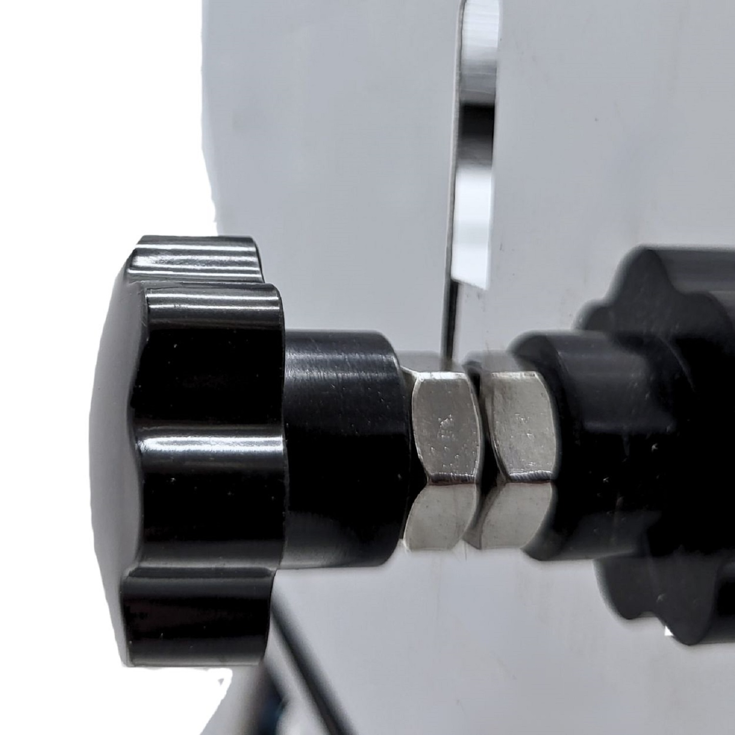 Ein schwarzer Knopf mit Sternform. Er ist mit einem silberfarbenen Metallteil verbunden.