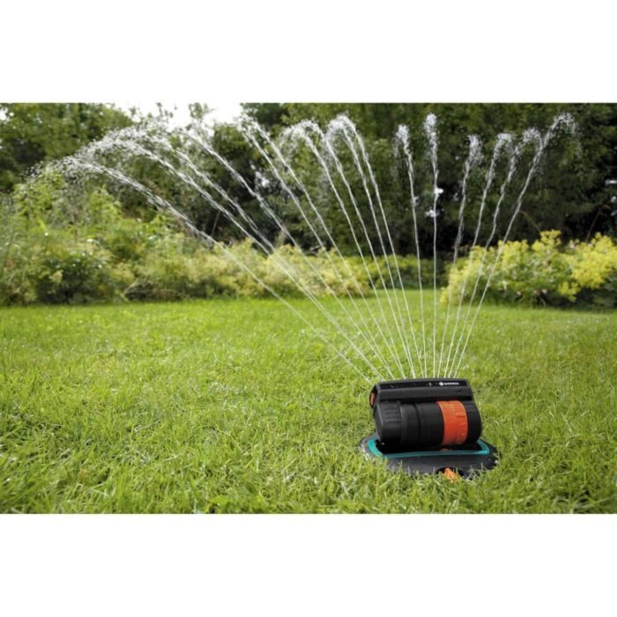 Rasensprenger auf Gras, sprüht Wasser. Der Sprenger ist schwarz und orange. Grünes Gras im Hintergrund.