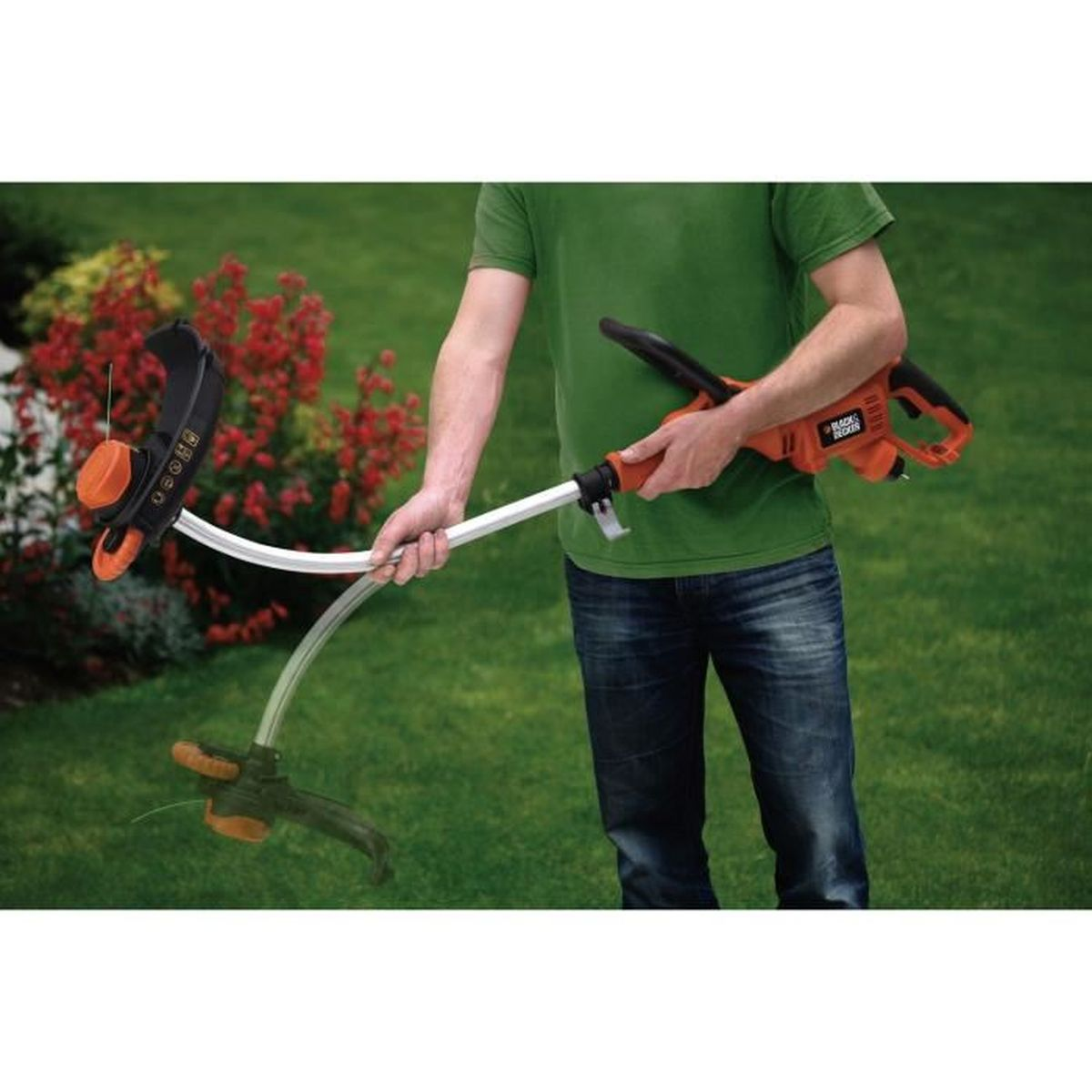 Una persona usando un recortador BLACK+DECKER en un área cubierta de hierba. El recortador es negro y naranja.