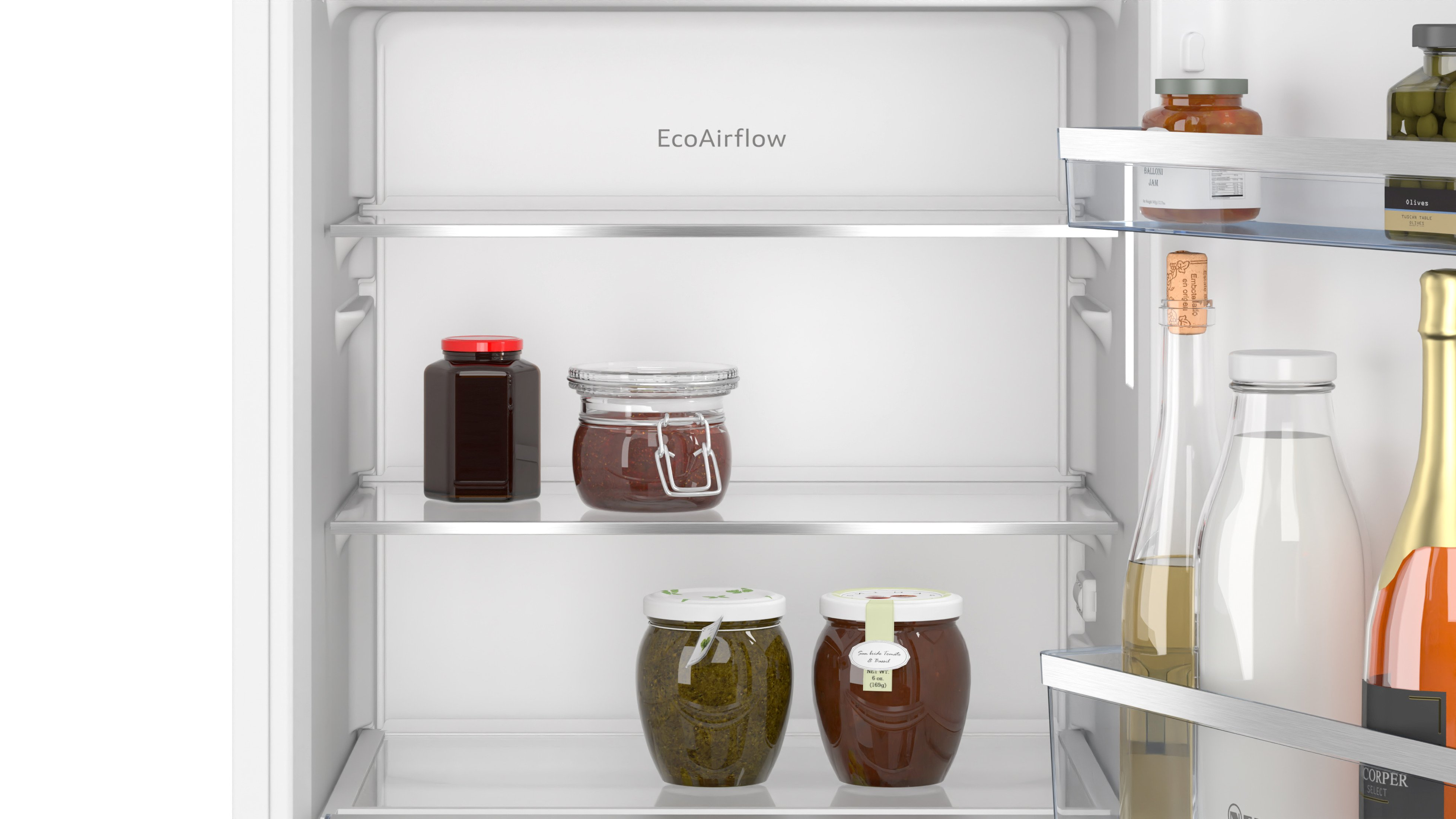 Ein Kühlschrankinnenraum mit Gläsern mit Lebensmitteln in den Regalen. Gläser mit roten Deckeln und eine Flasche sind vorhanden.