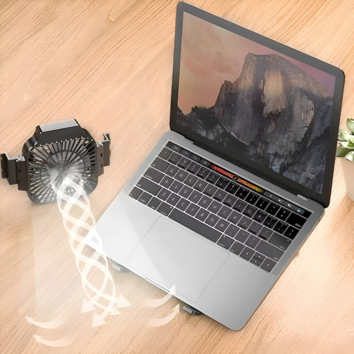 Laptop mit Kühlventilator. Der Laptop steht auf einem Holzschreibtisch.