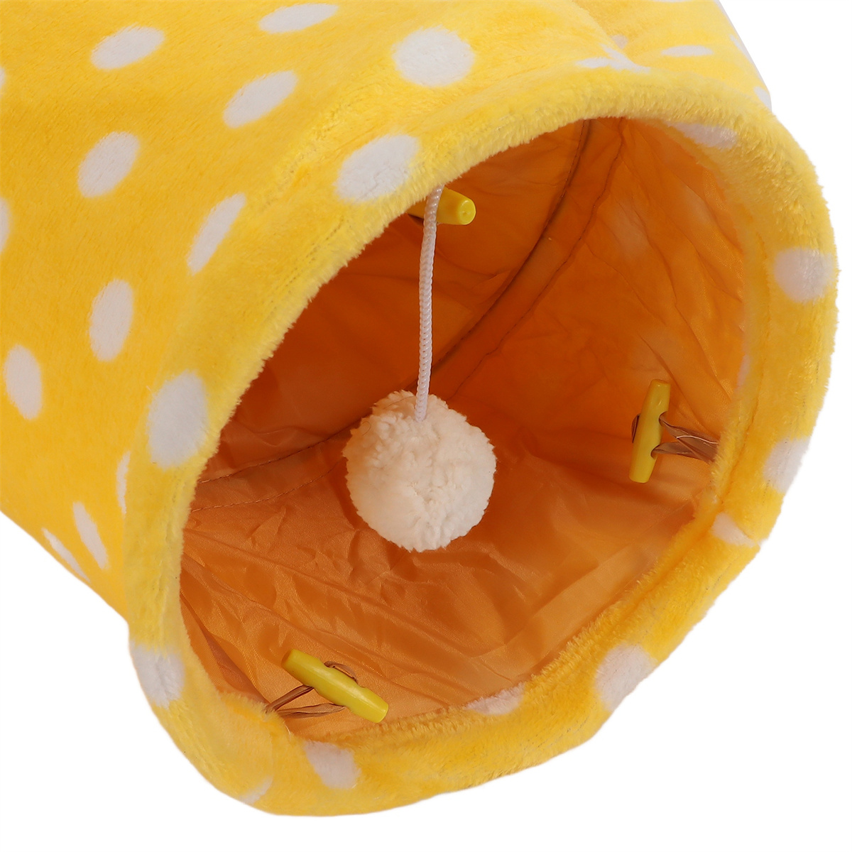 Ein gelber Katzentunnel mit weißen Tupfen und einem hängenden Spielzeug innen.